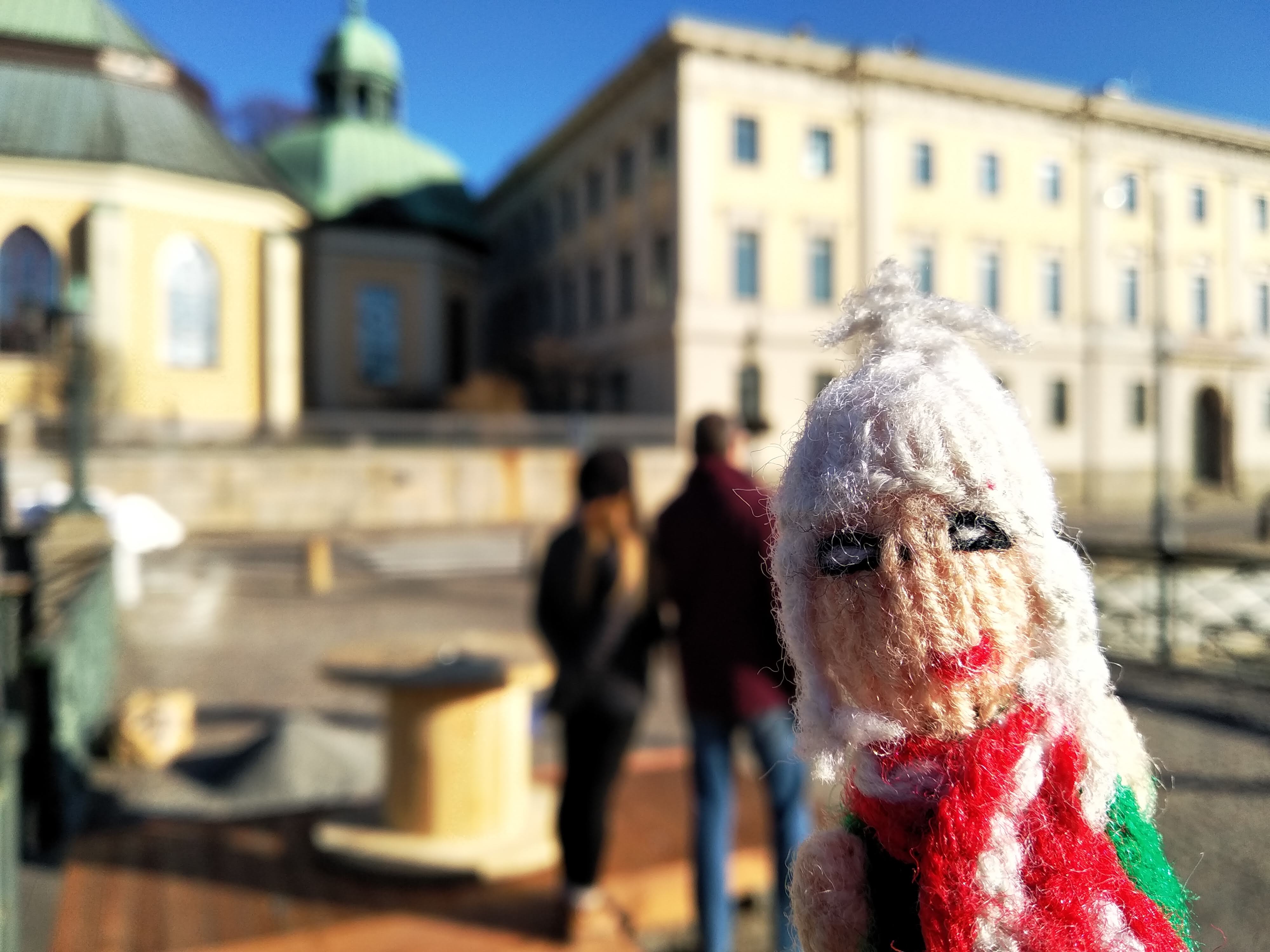 Finger puppet photo-bombs influencers on the bridge over Stora Hamnkanalen at Korsgatan and Tyska kyrkan in Gothenburg.