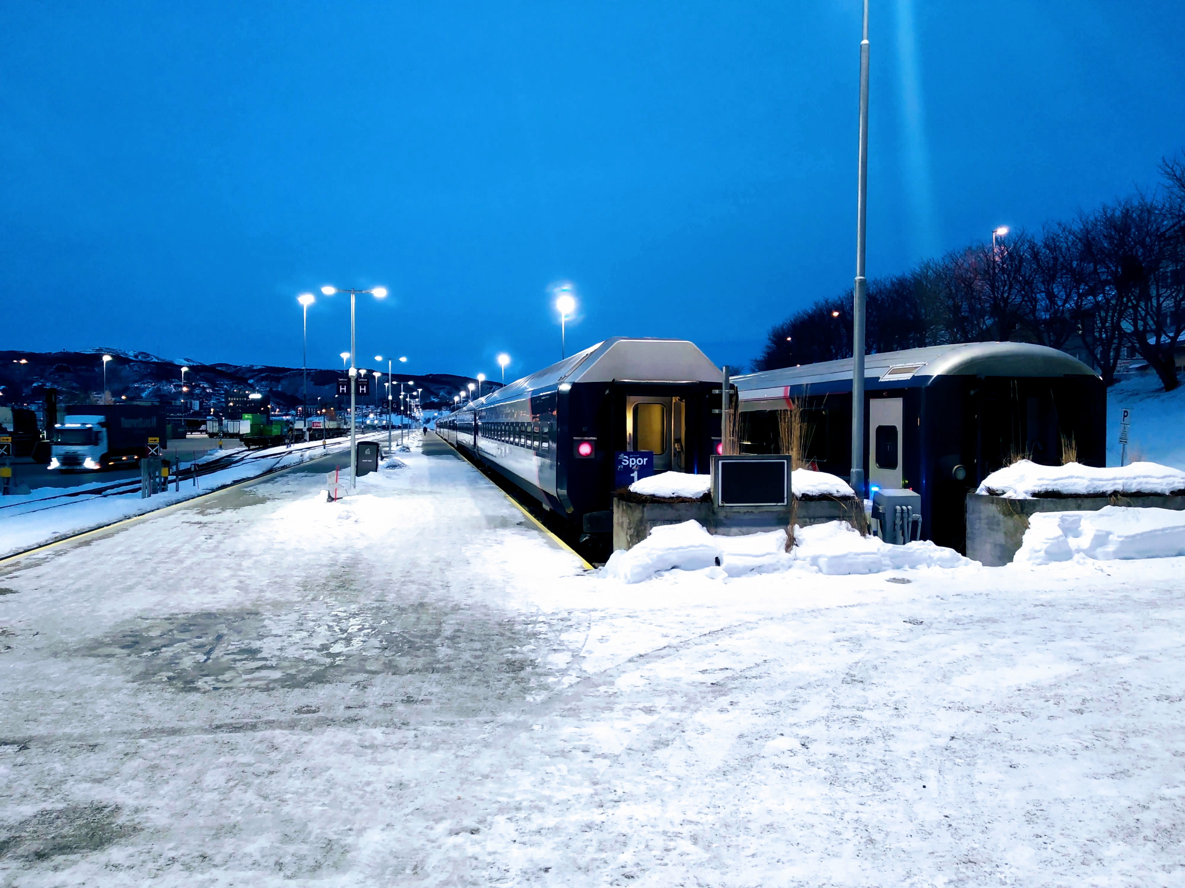 Snowy platforms at Bodø S where a night train on platform 1 is waiting to depart.