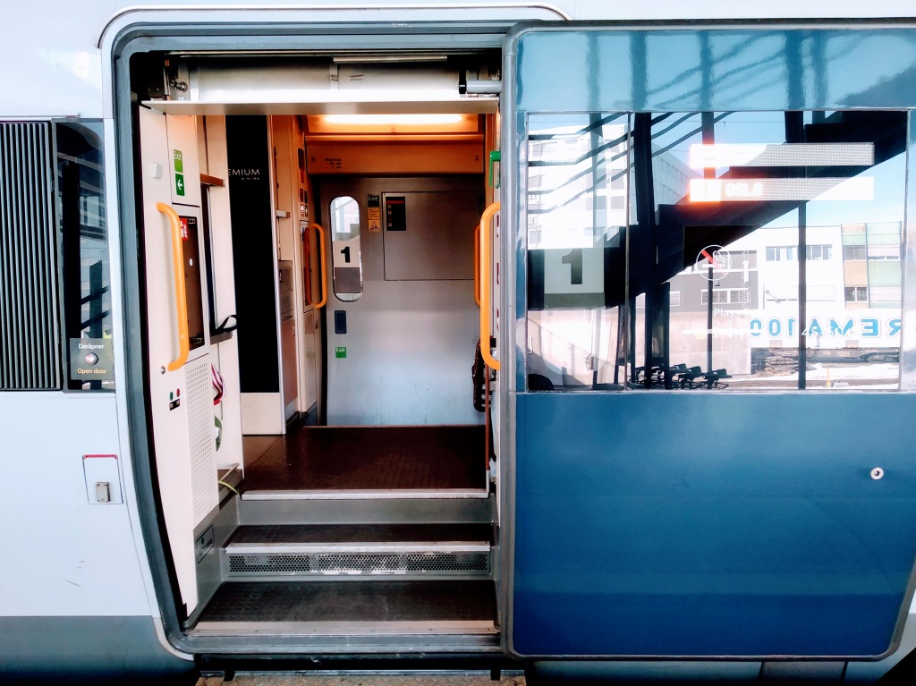 Photograph of an open door into a first class carriage on an SJ Nord train between Trondheim and Oslo.
