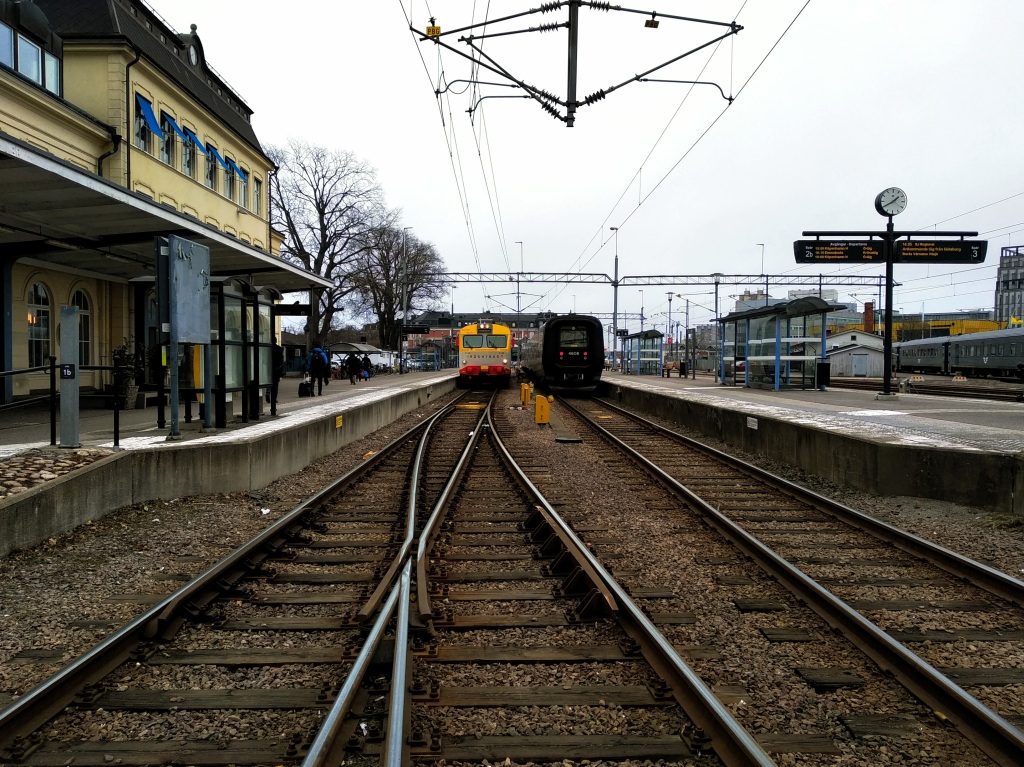 Two trains wait on adjacent platforms at Kalmars Centralstation.