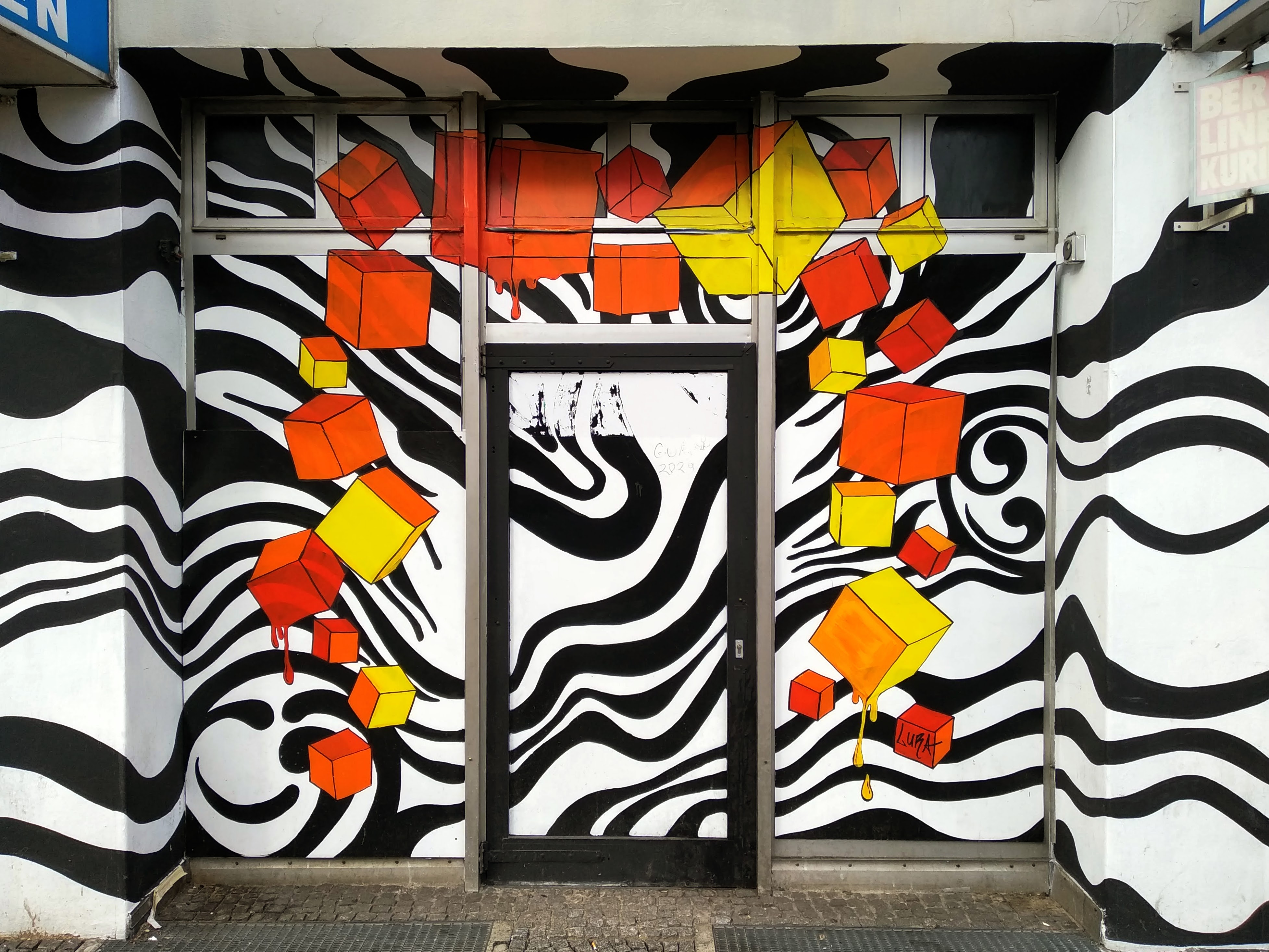 A door with zebra stripes and orange and yellow cubes.