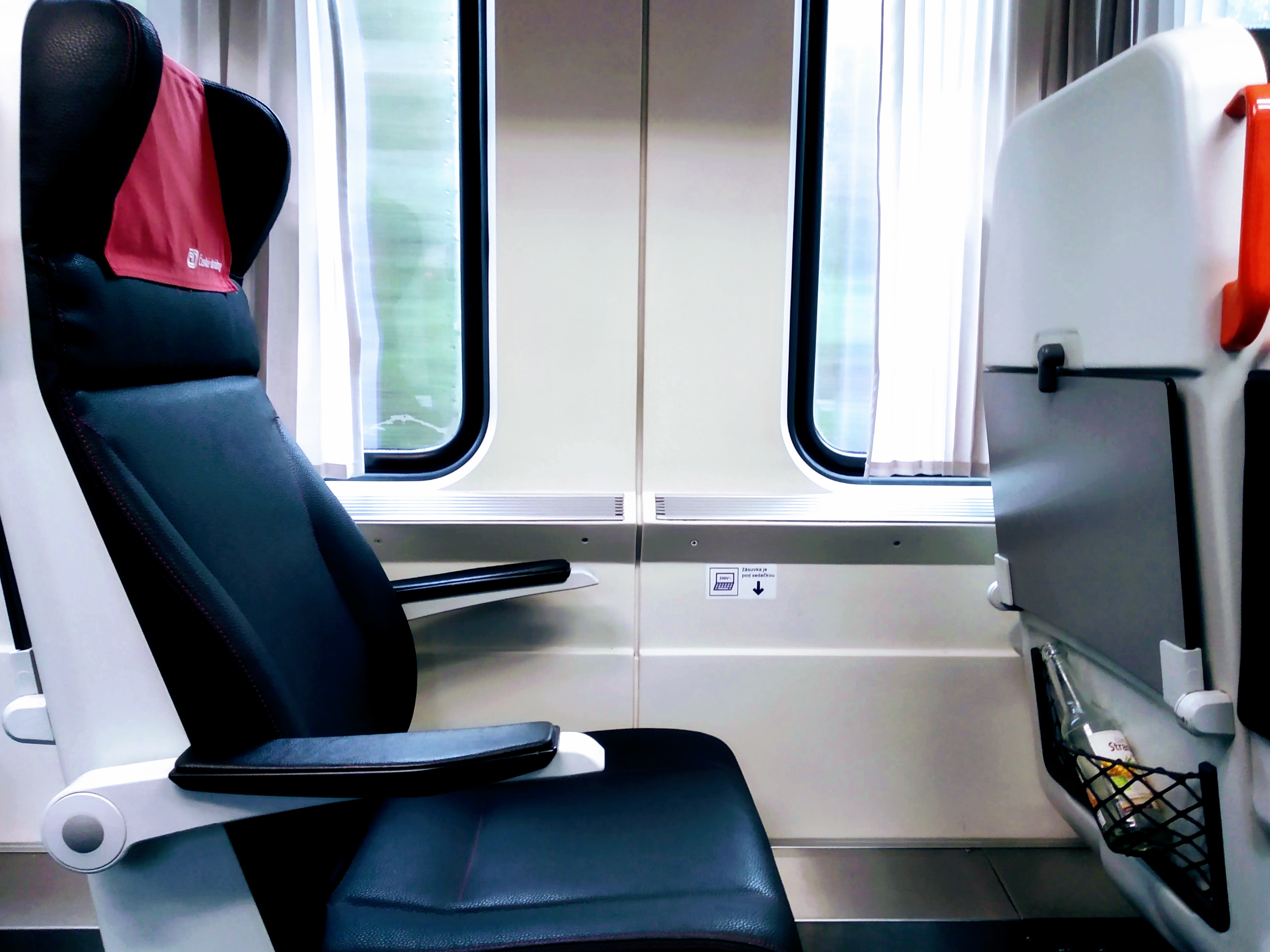 A leather seat between two windows offers no view.