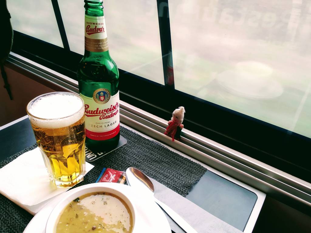 Lentil soup with ginger and coriander, a pint of Budvar, and a puppet in a ČD Railjet dining car,