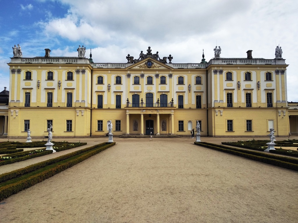 The back of the yellow and cream baroque palace palace, as seen from the palace gardens.