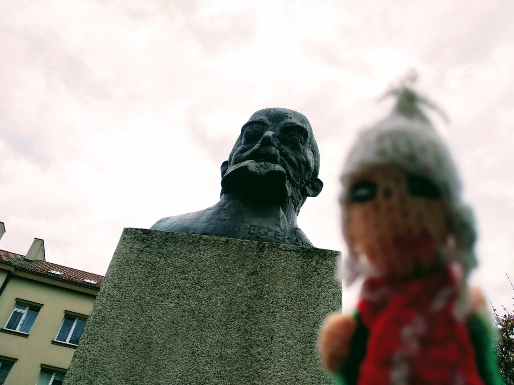 Fingra Pupo in front of a bronze bust of Ludwik Lejzer Zamenhof