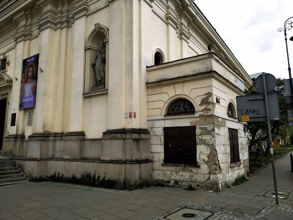 A small house build onto the corner of a larger building.