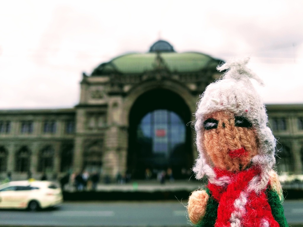 A slightly haggard finger puppet in front the railway station in Nuremberg.