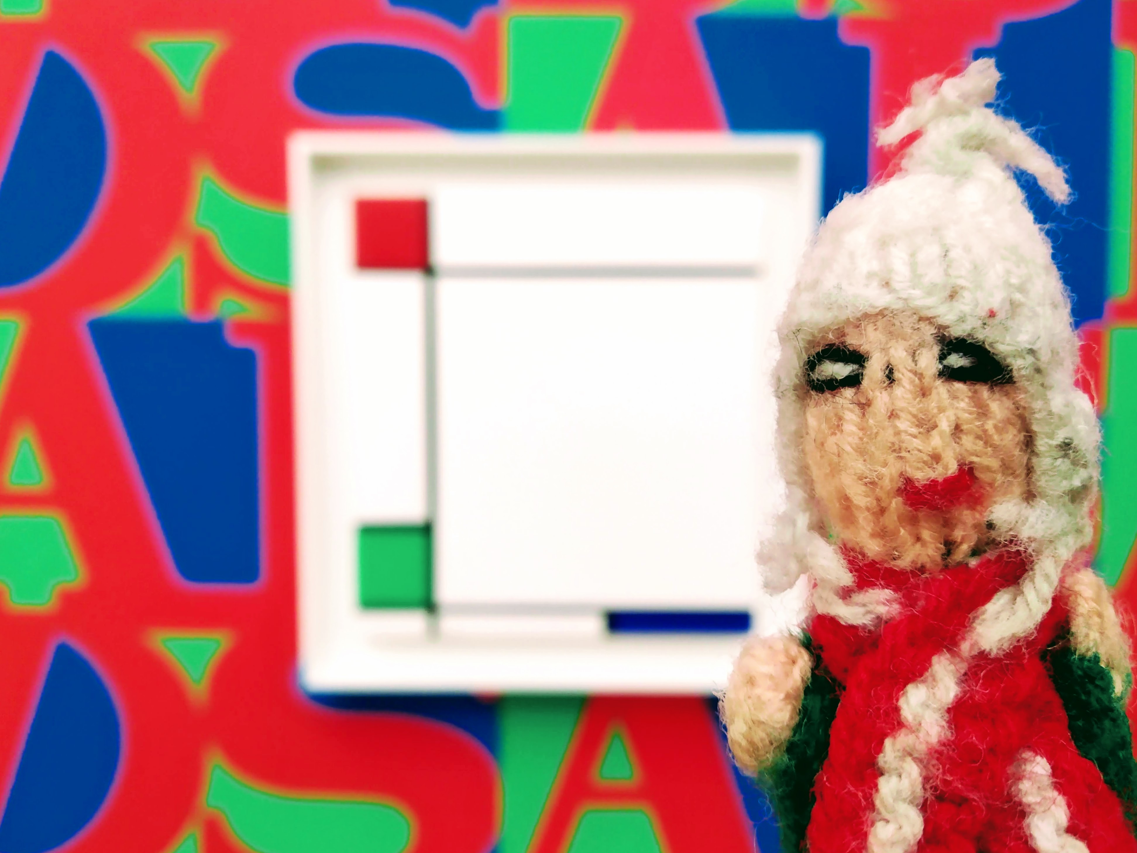 Puppet in front of one of General Idea's "Infected Mondrian" series.
