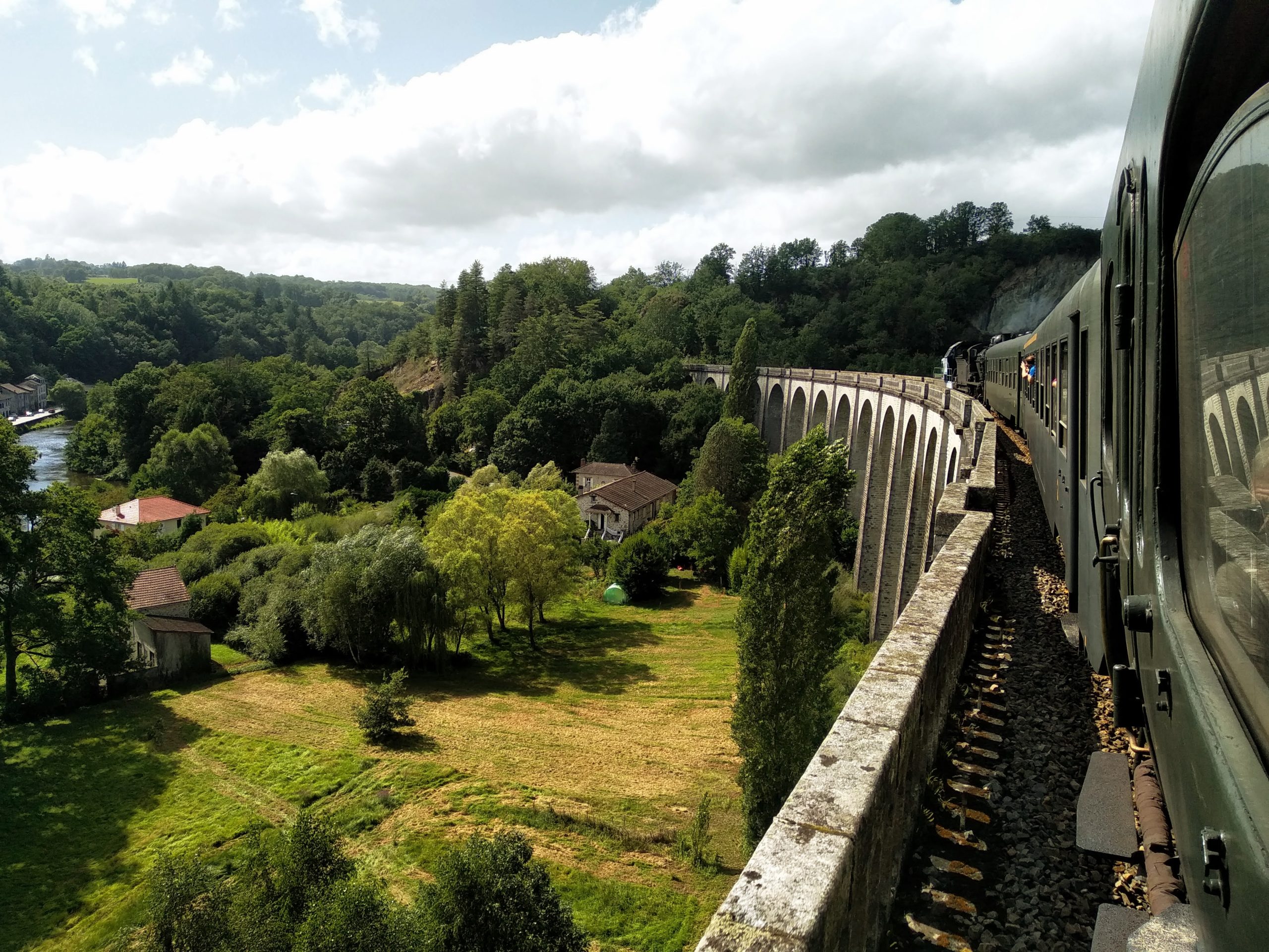 A view from a steam train, looking towards the locomotive, as it crosses the 22-arch viaduct at Saint-Léonard-de-Noblat.