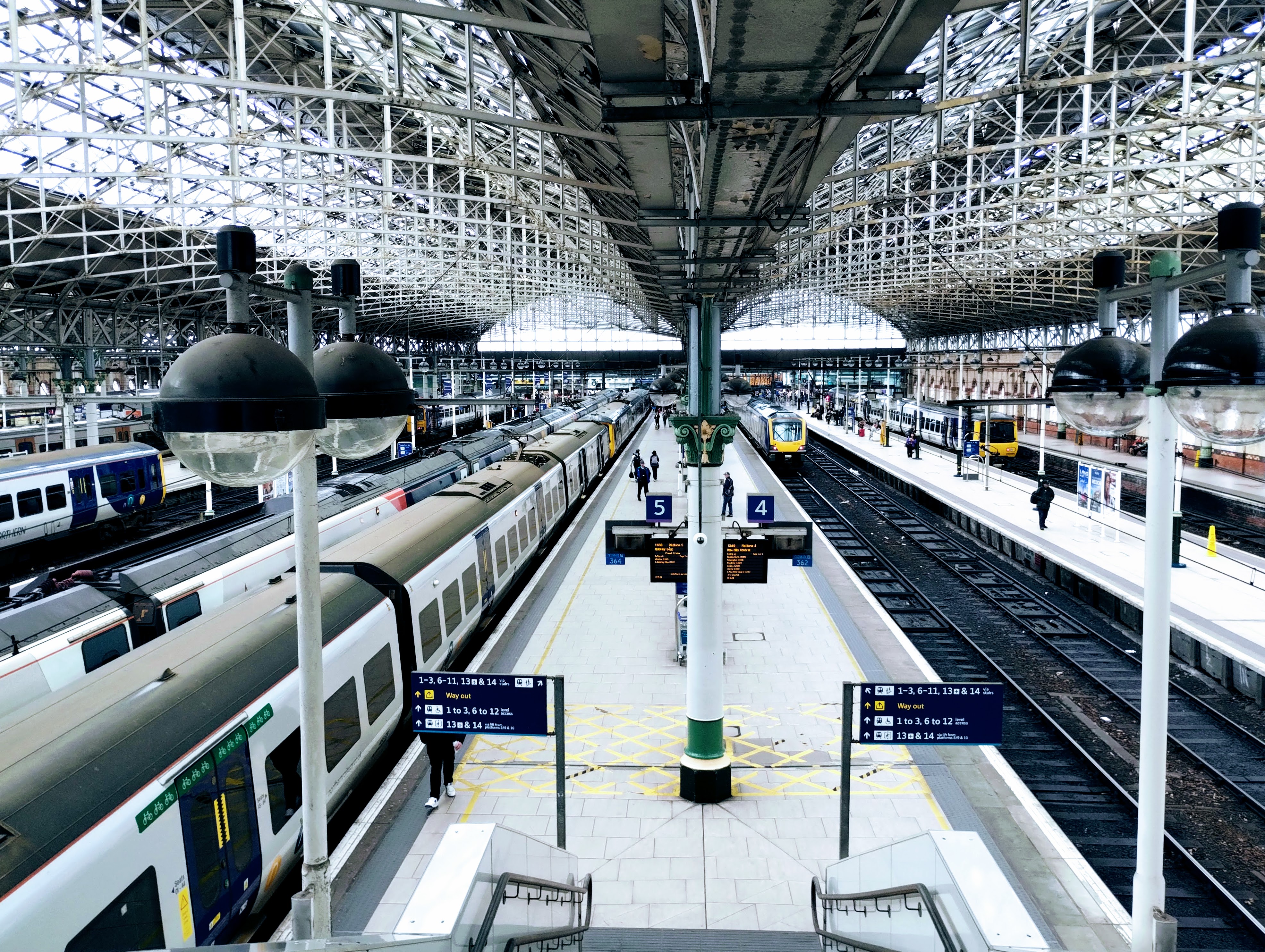 Photograph from a footbridge looking down platforms five and four of Manchester Piccadilly station.