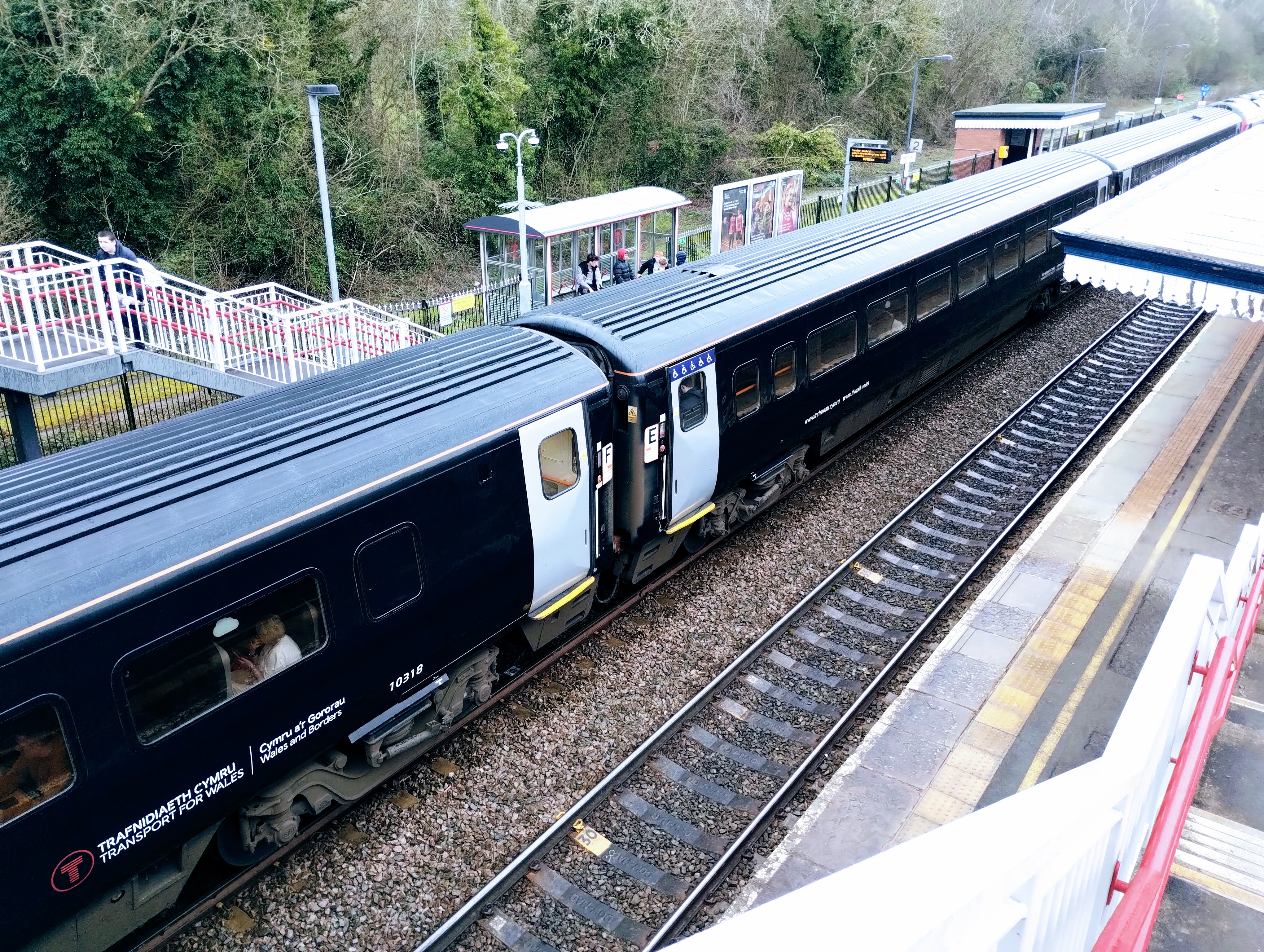 A Transport for Wales service waiting at a platform in a train station.
