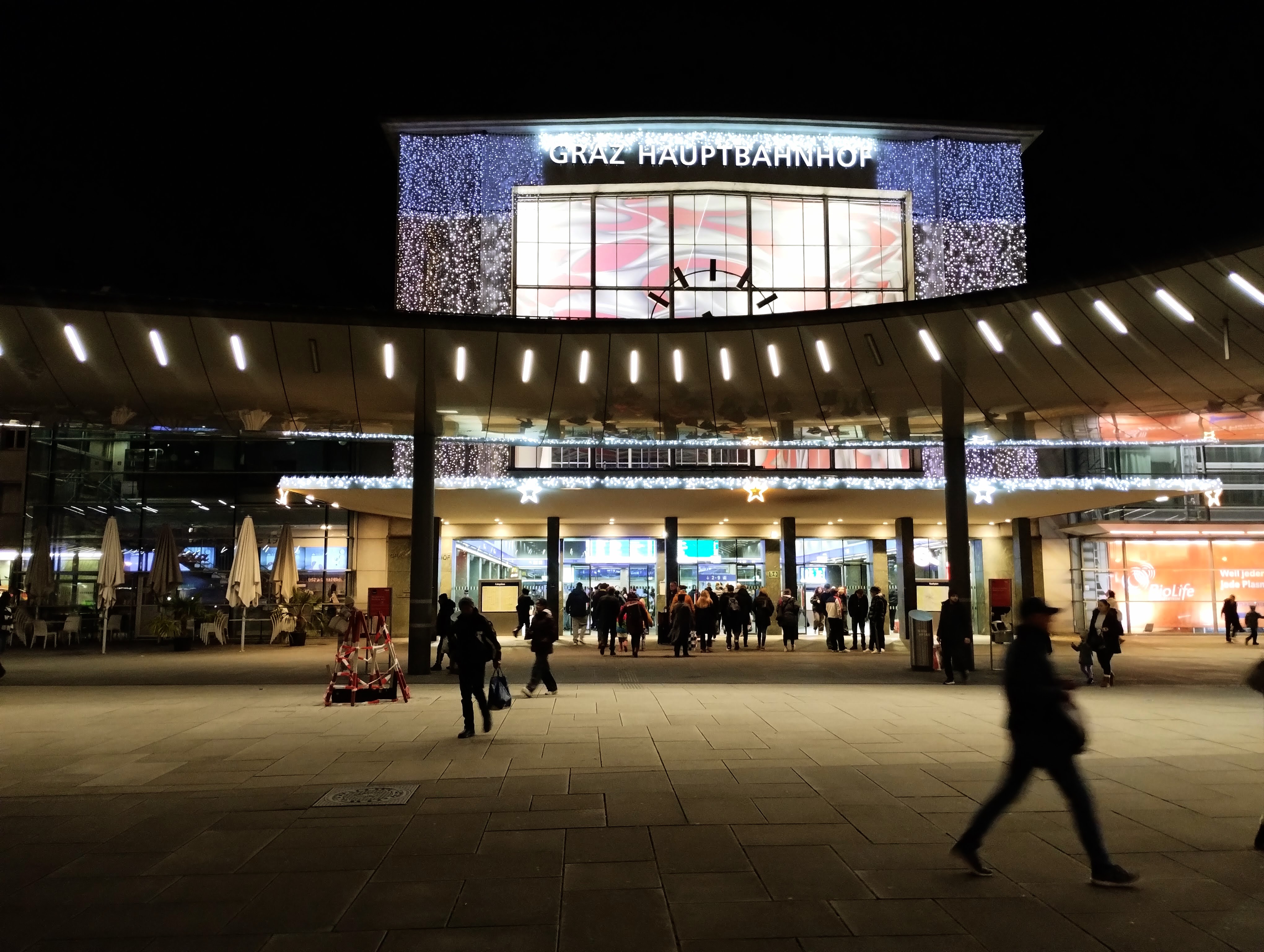 The main entrace to Graz Hauptbahnhof which is covrered with white and blue lights for Christmas.