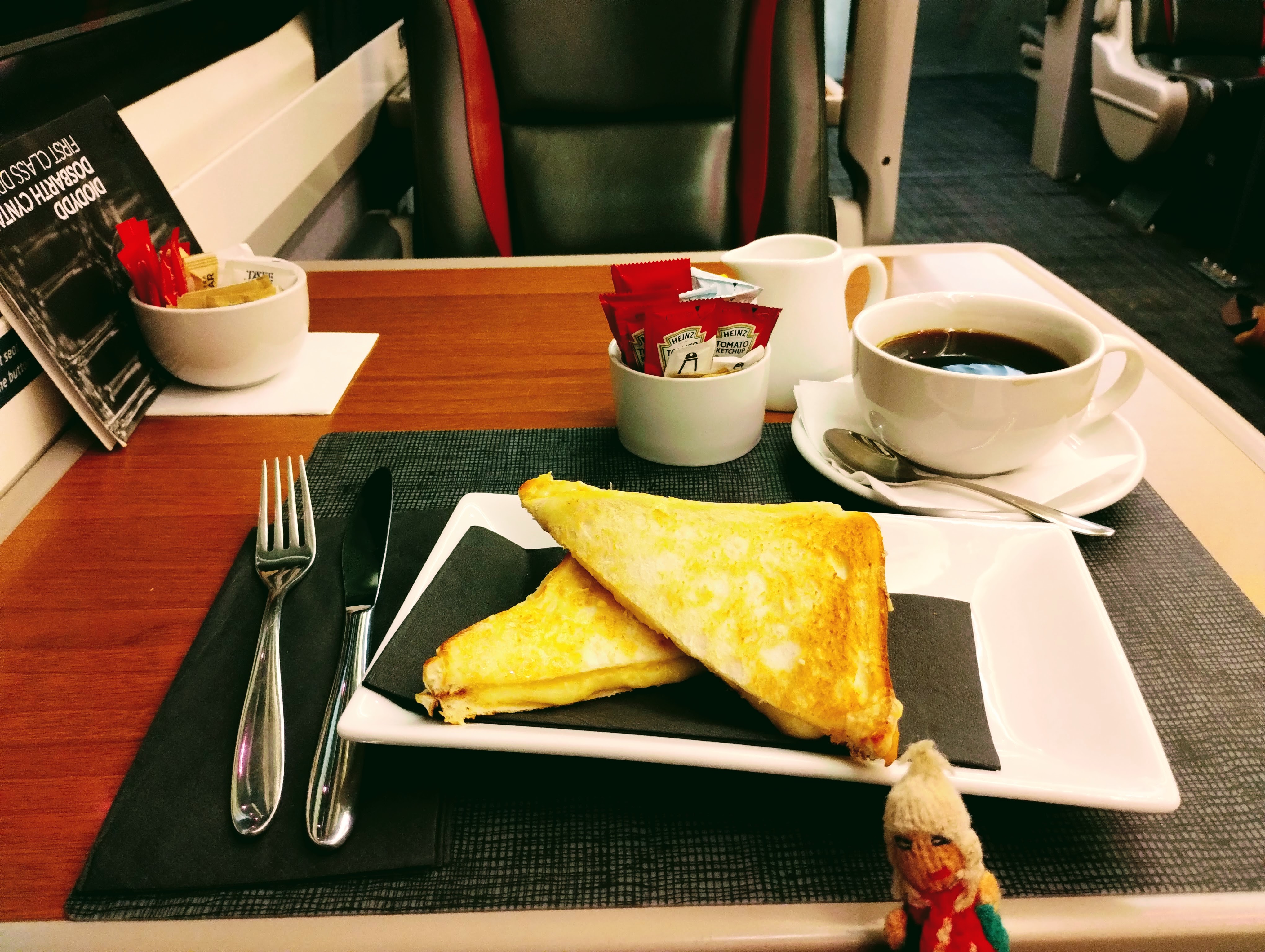A puppet, a toasted cheese sandwich, and a mug of coffee.