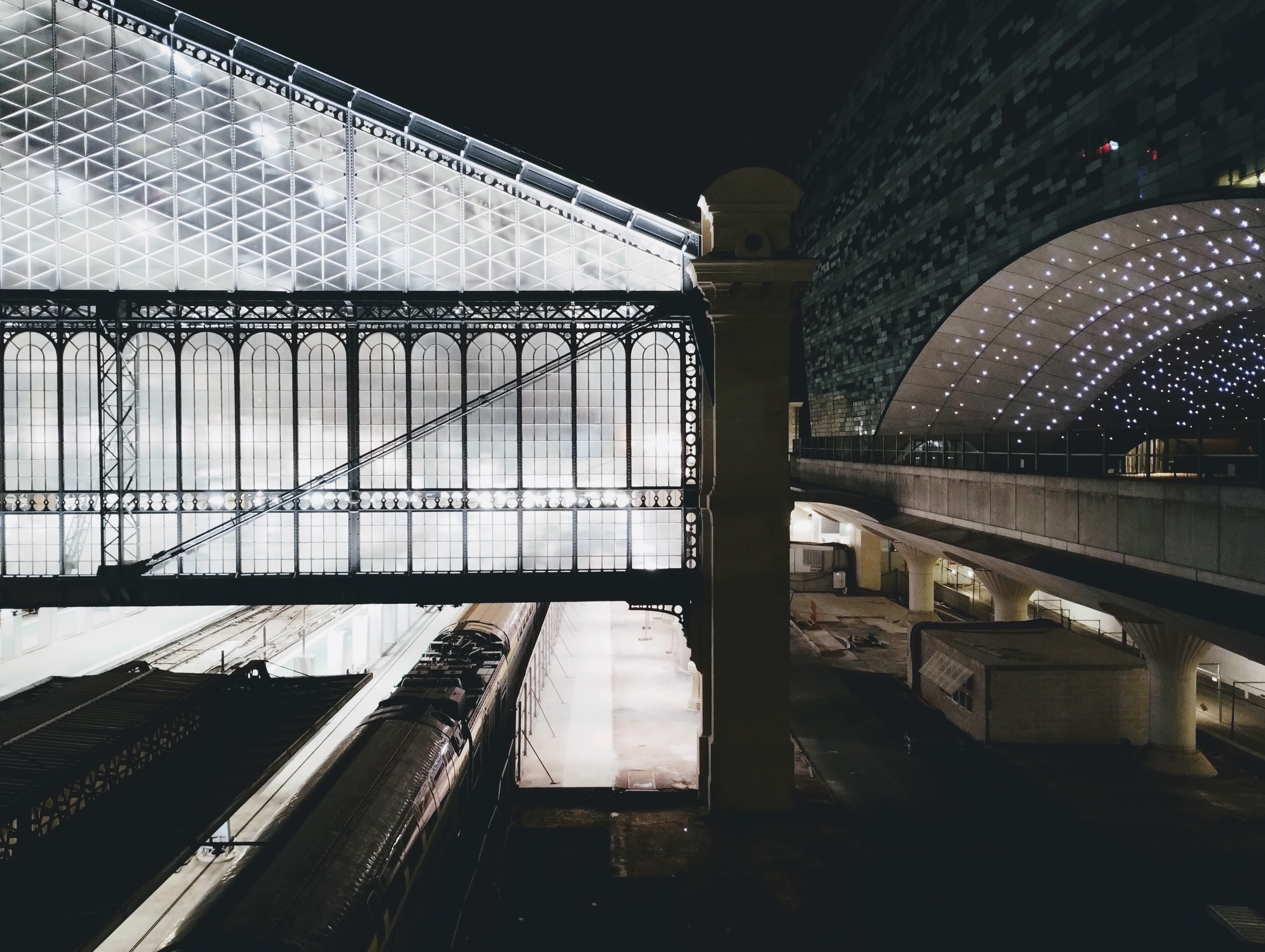 The glass end of the train shed at Paris Austerlitz illuminated in the dark.