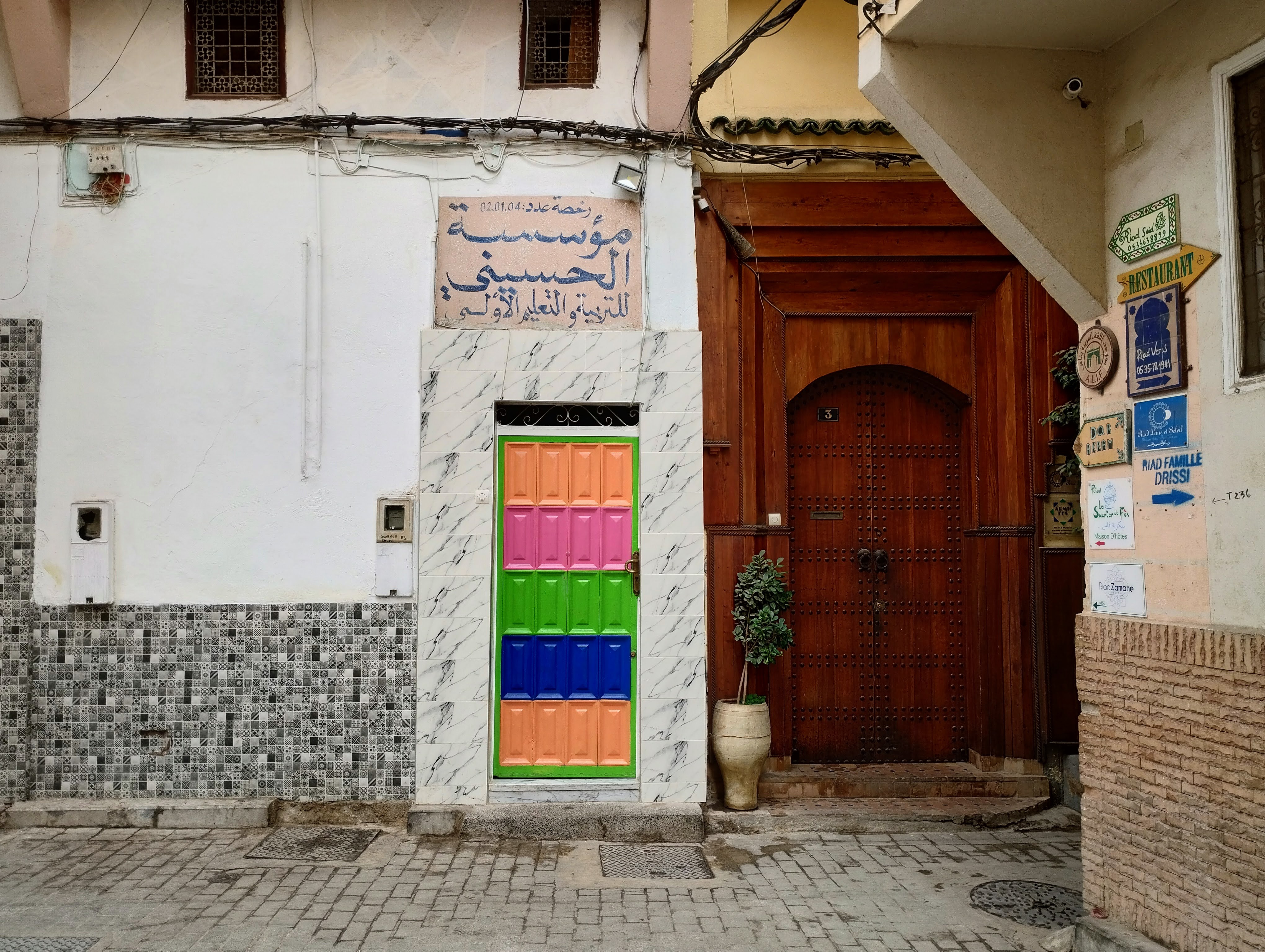 A multi-coloured panel door set in a white wall.