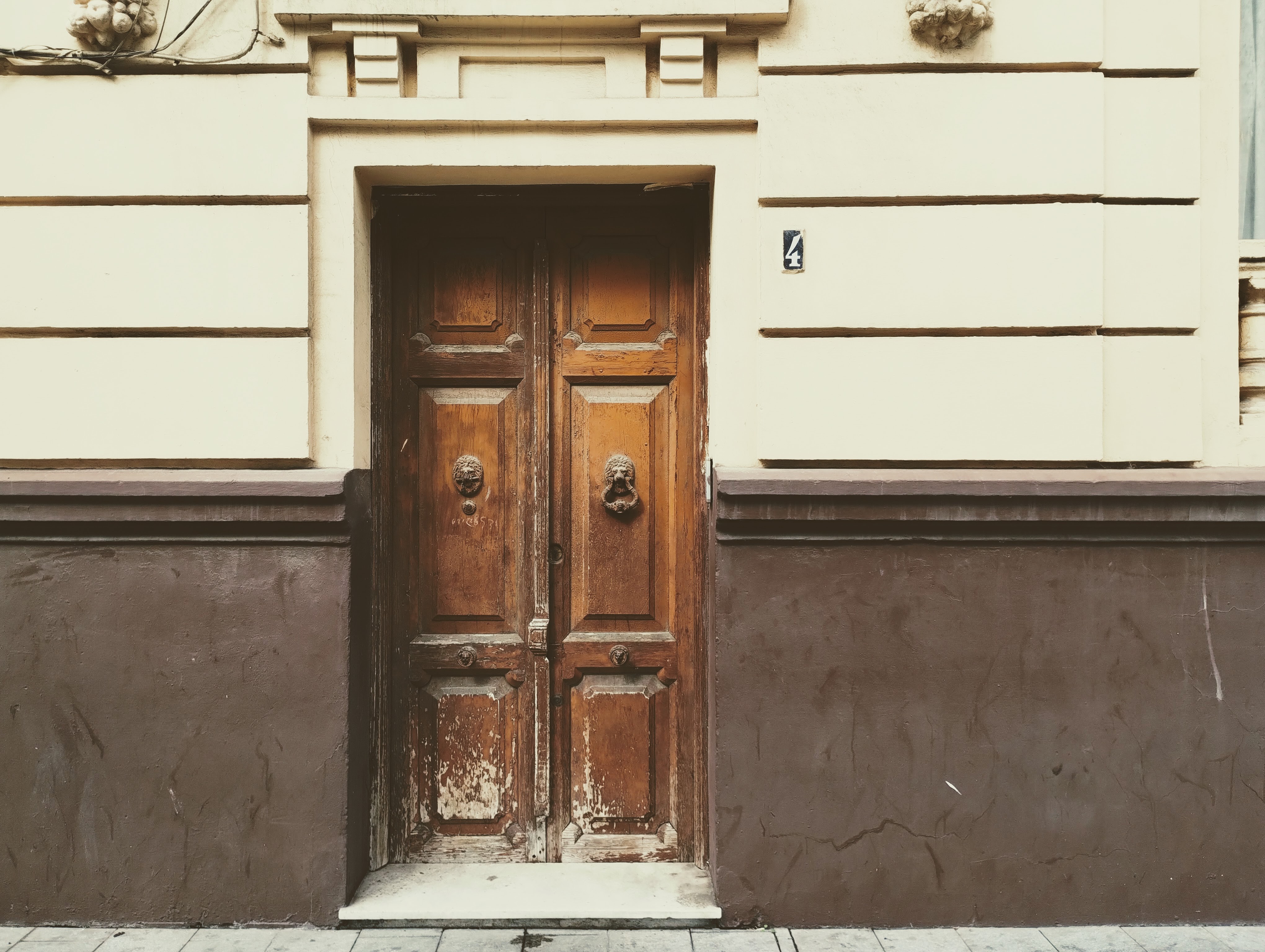 A solid wooden door with large metal knockers.
