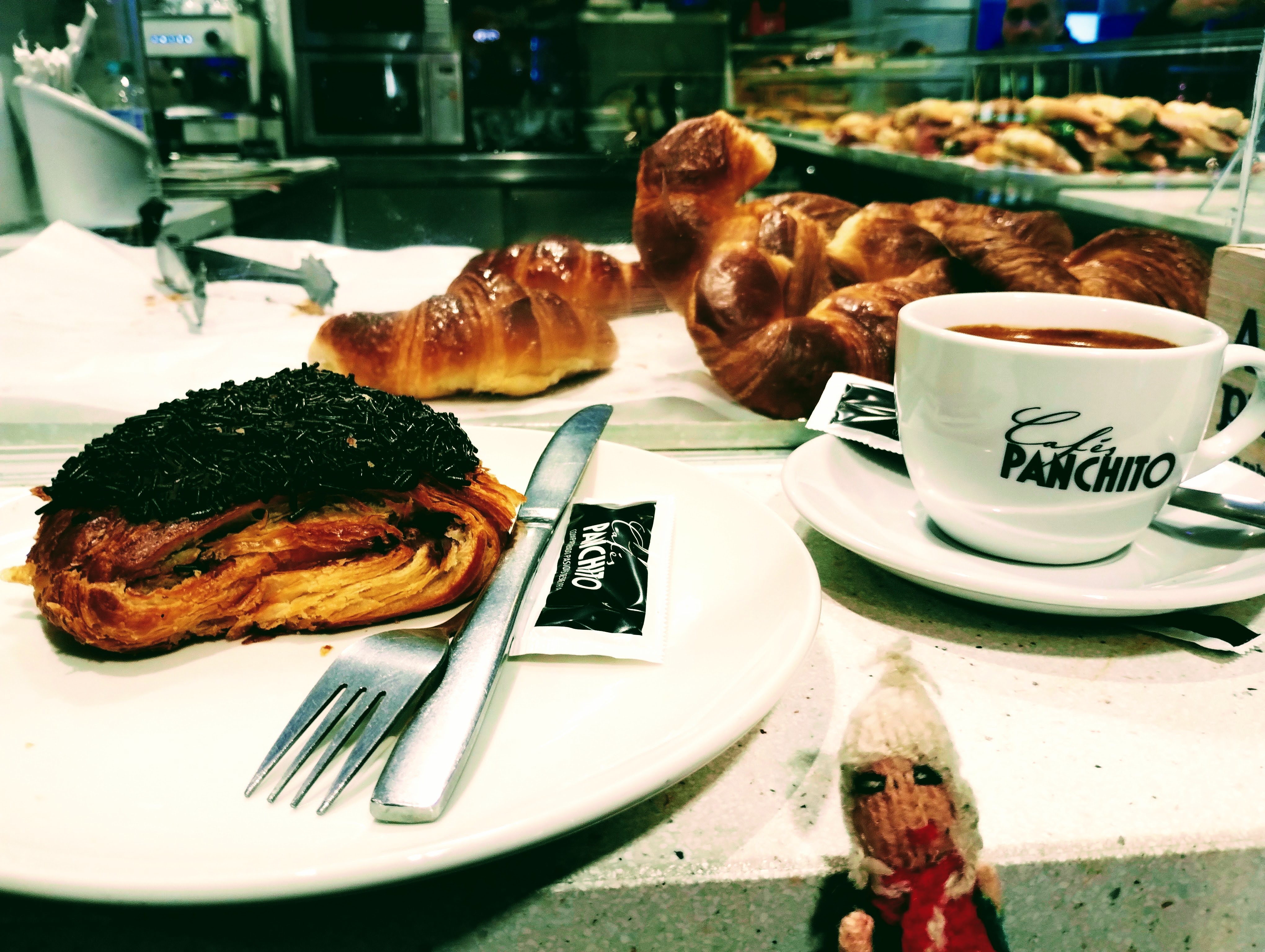 A large chocolate pastry and a cup of coffee.