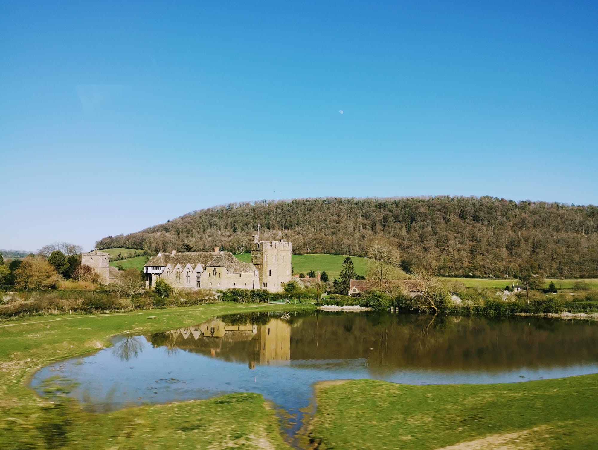 Stokesay Castle, one of the finest surviving fortified manor houses in England, reflected in a lake.