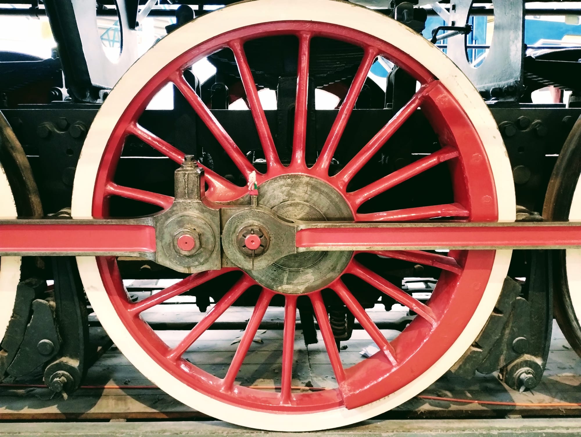 A puppet on a large red wheel from a steam locomotive.
