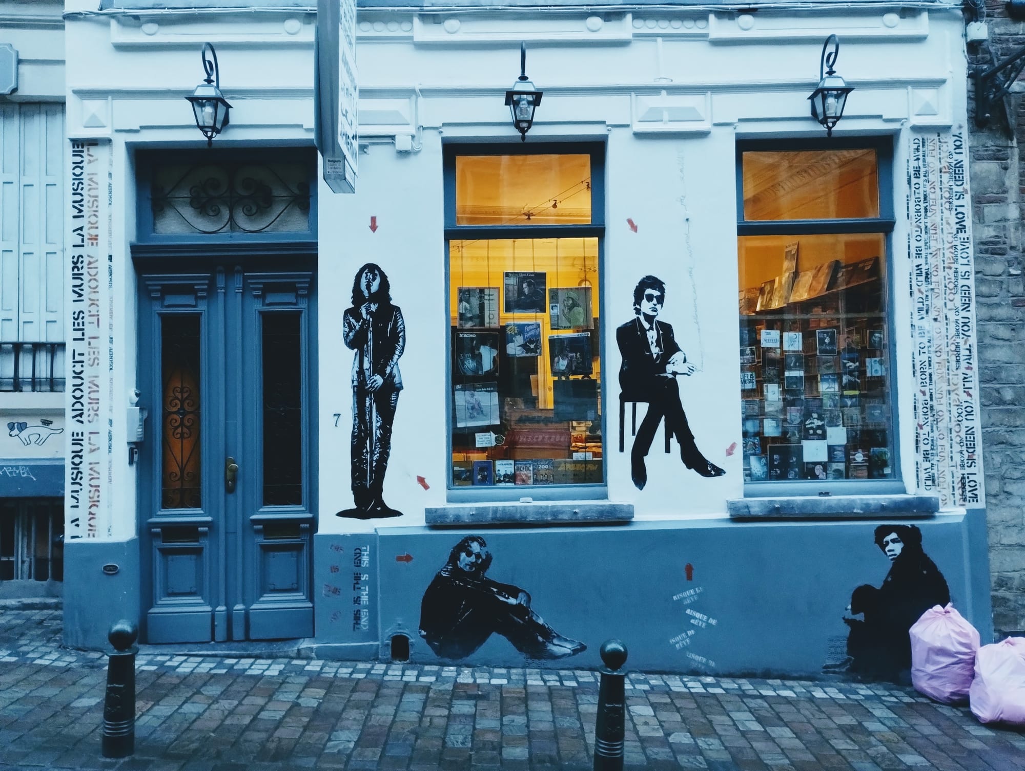 The front of a second-hand record shop on Rue du Chêne in Brussels. The tall wooden door on the left is painted blue and has windows protected by ironwork.