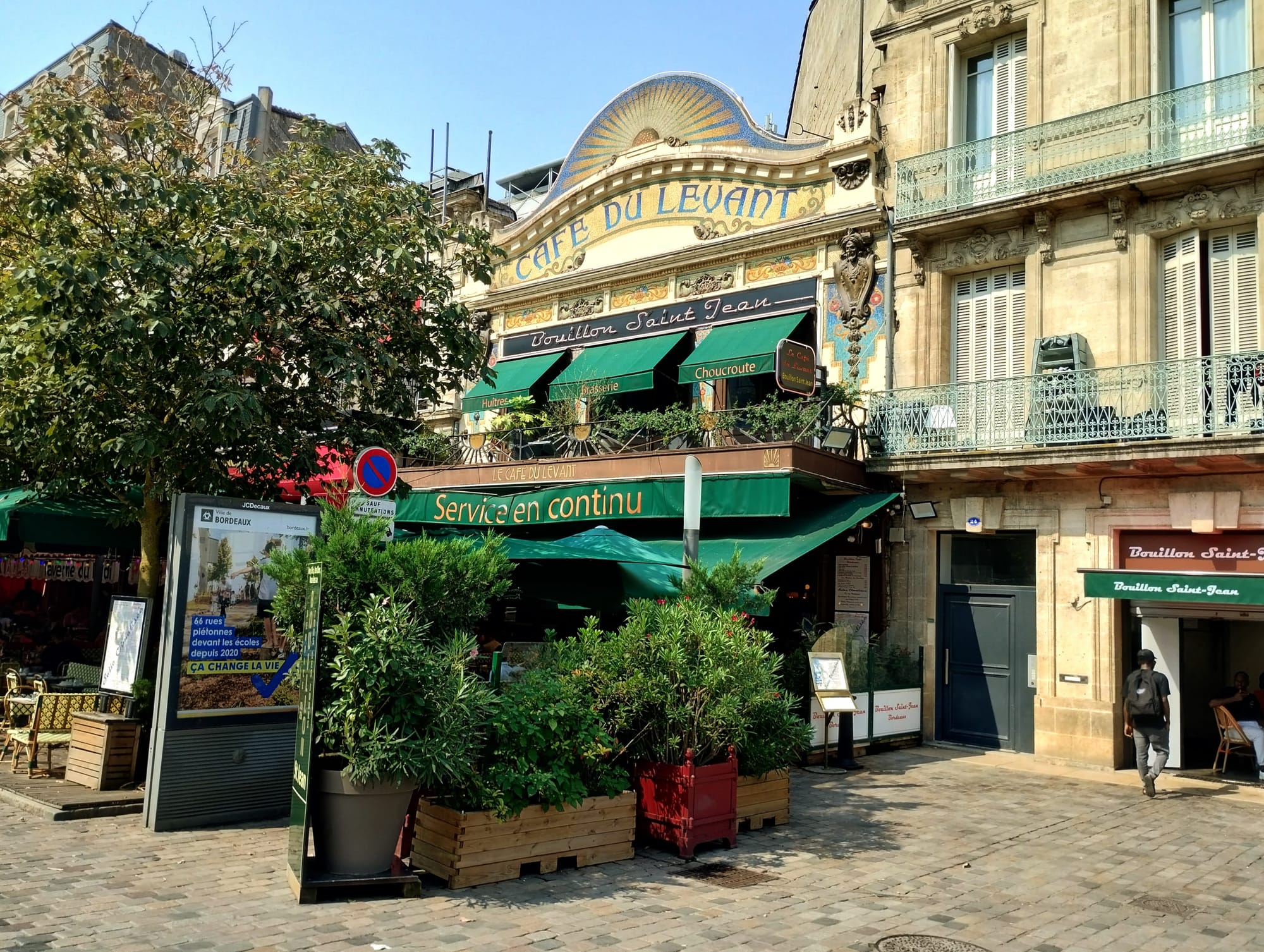 Exterior shot of the "Café du Levant" in Bordeaux with its distinctive facade and green awnings.