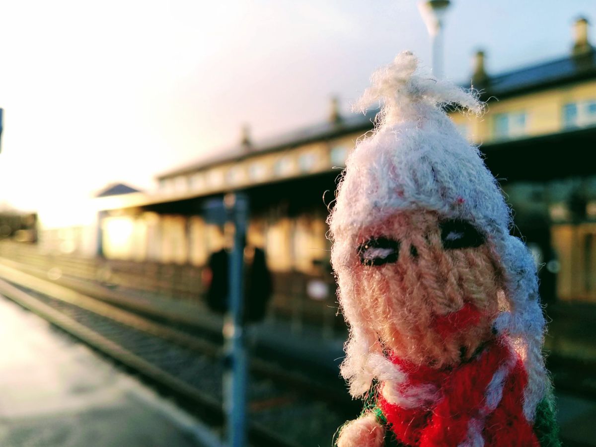 Finger Puppet waits for a train at a sun-bathed Struer station.