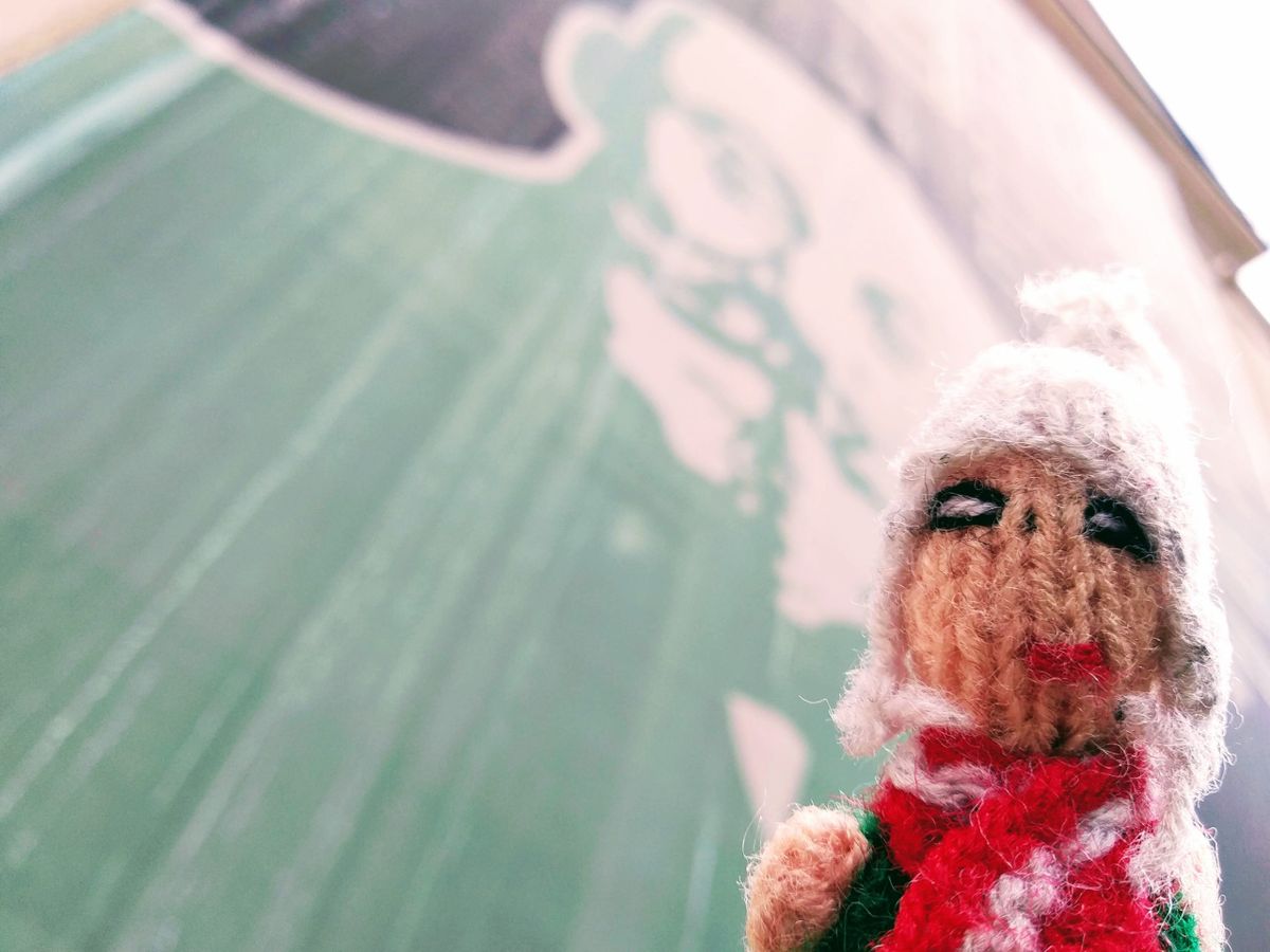 A multi-lingual finger puppet underneath a representation of Ludwik Lejzer Zamenhof.