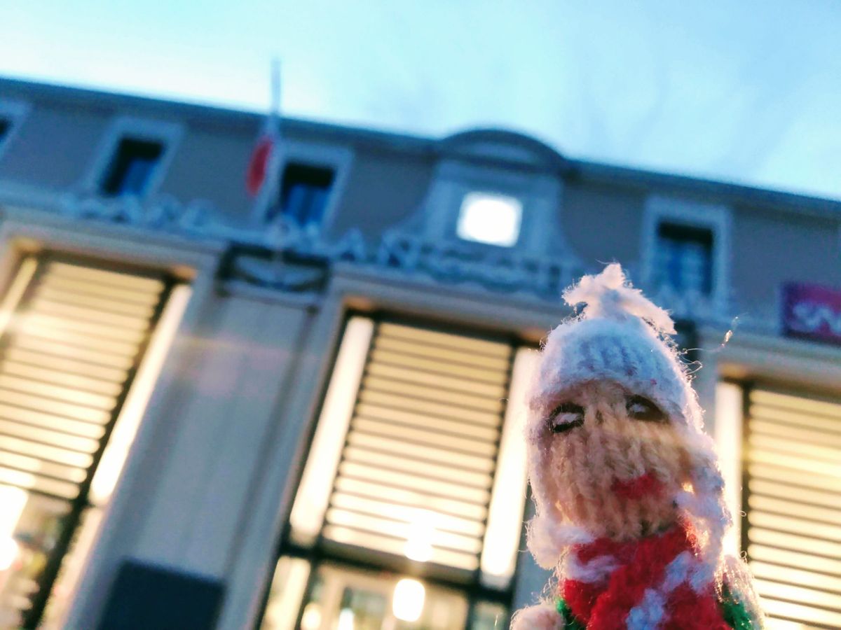 A weary finger puppet works it in front of the Gare Angoulême.