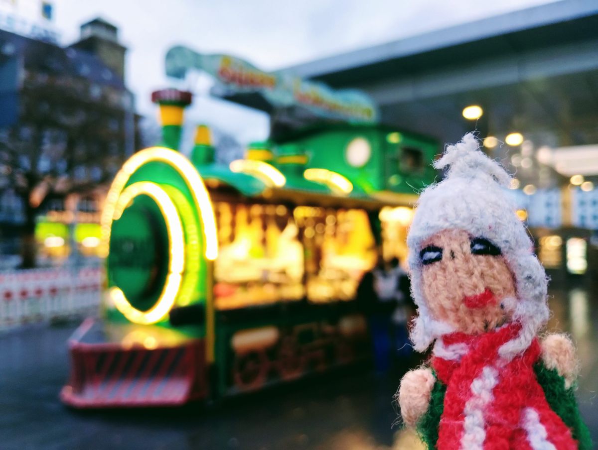 An elated finger puppet does its best to contain its child-like glee in front of a giant toy train.