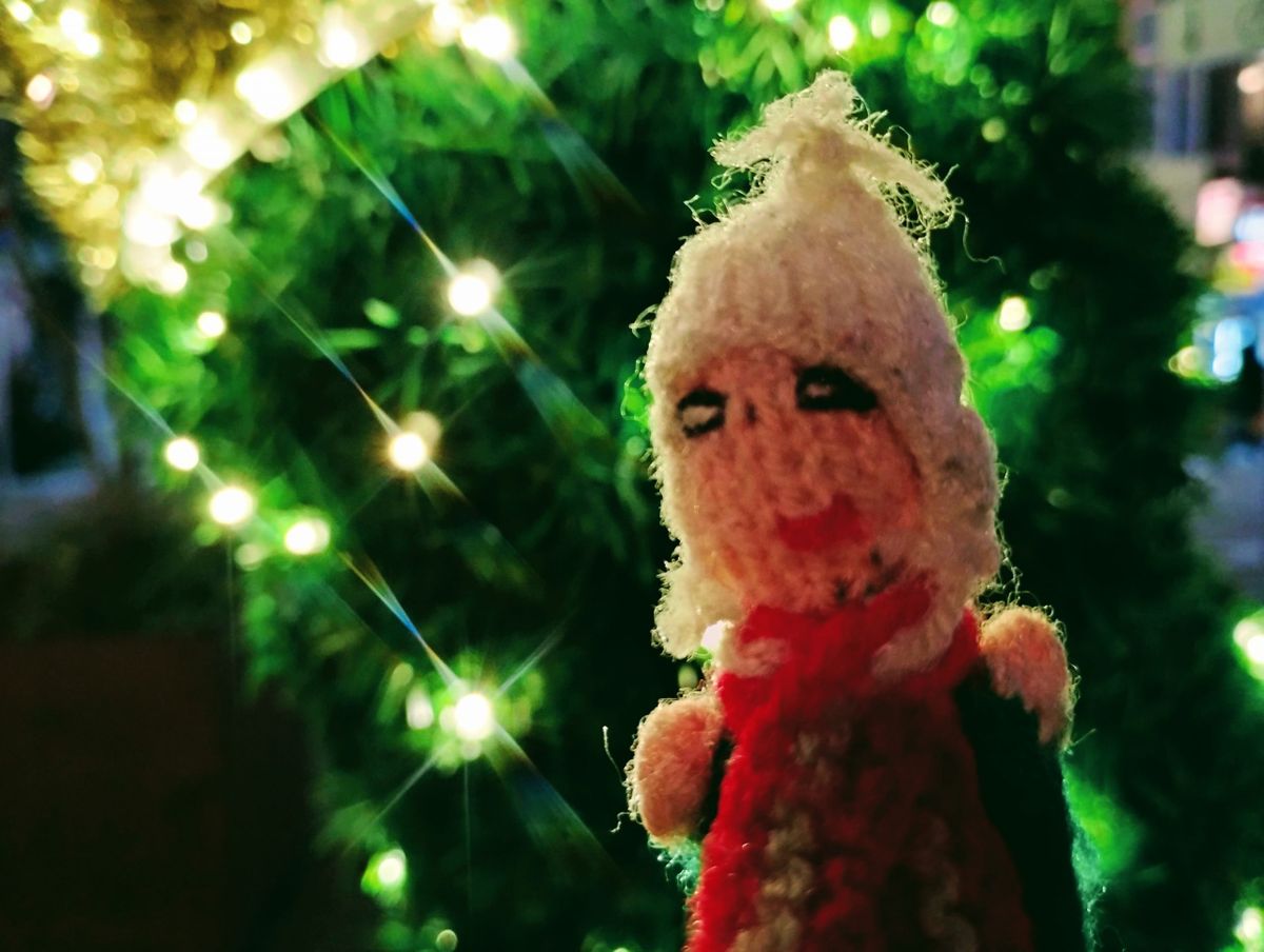 Puppet in front of a Christmas tree.