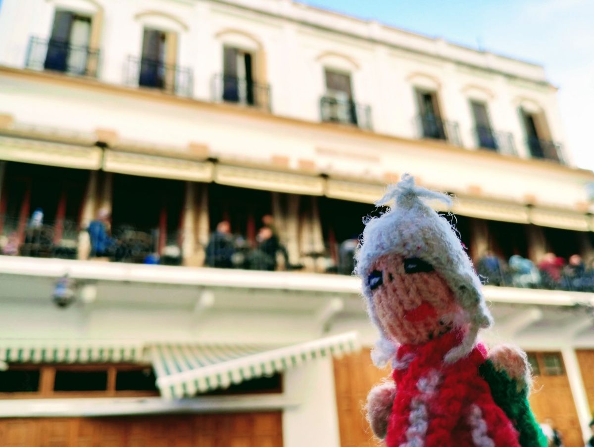 Freshly-arrived in Tangier, a nervous Peruvian finger puppet in front of a colonial-era hotel with a green and white striped awning and a busy balcony.