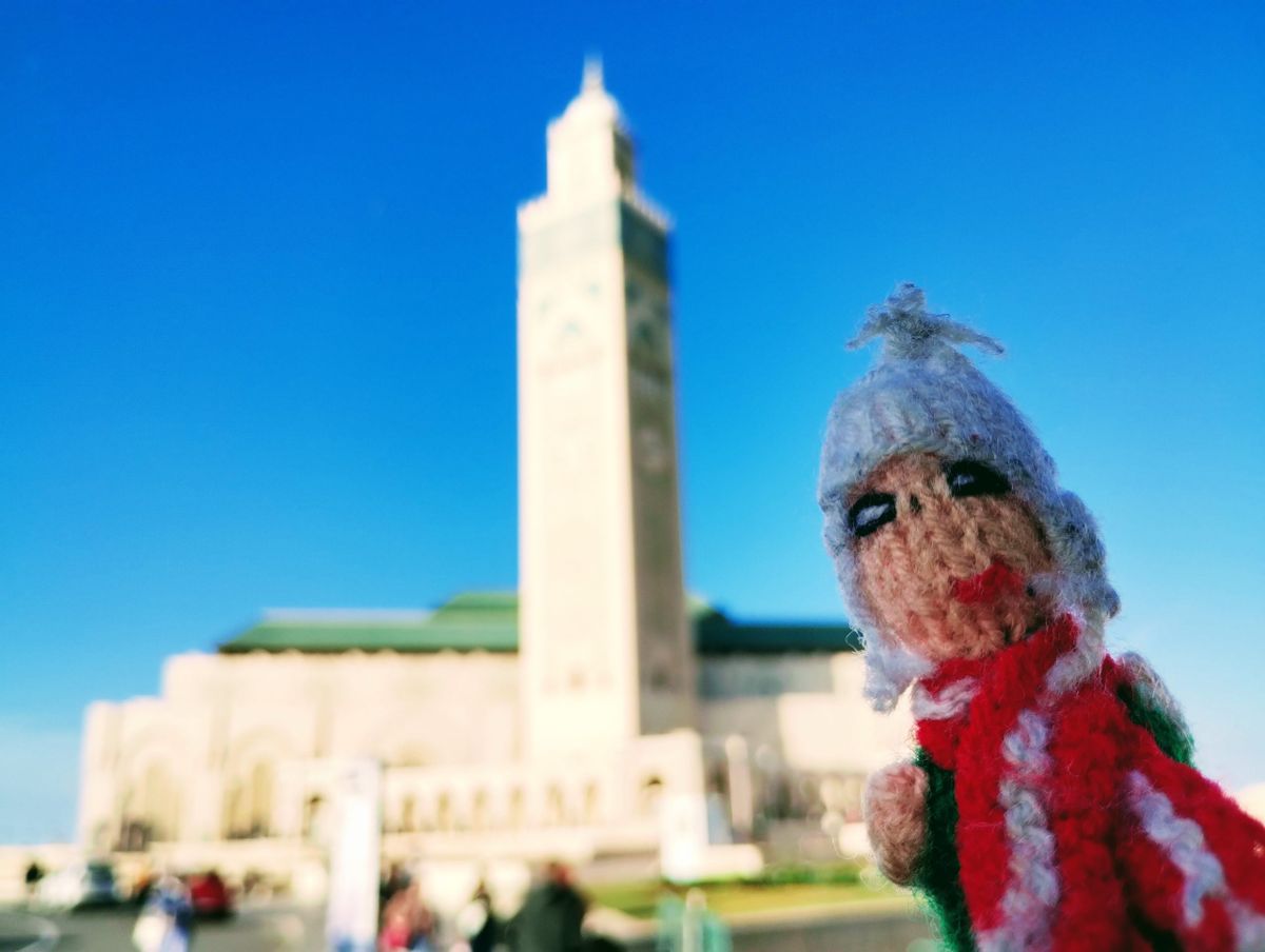 Puppet comparing sizes with the minaret of the Hassan II Mosque.