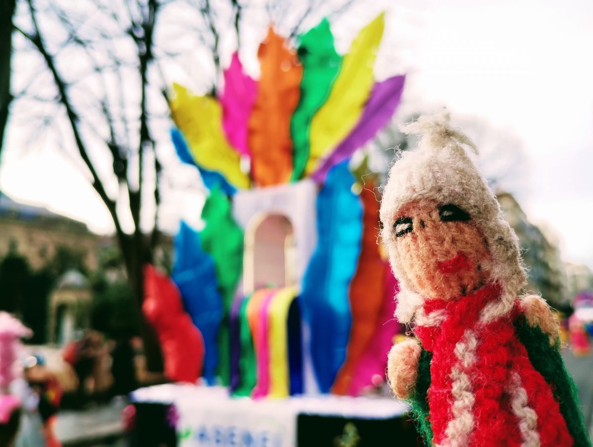 Puppet enjoying a rainbow-coloured carnival float.