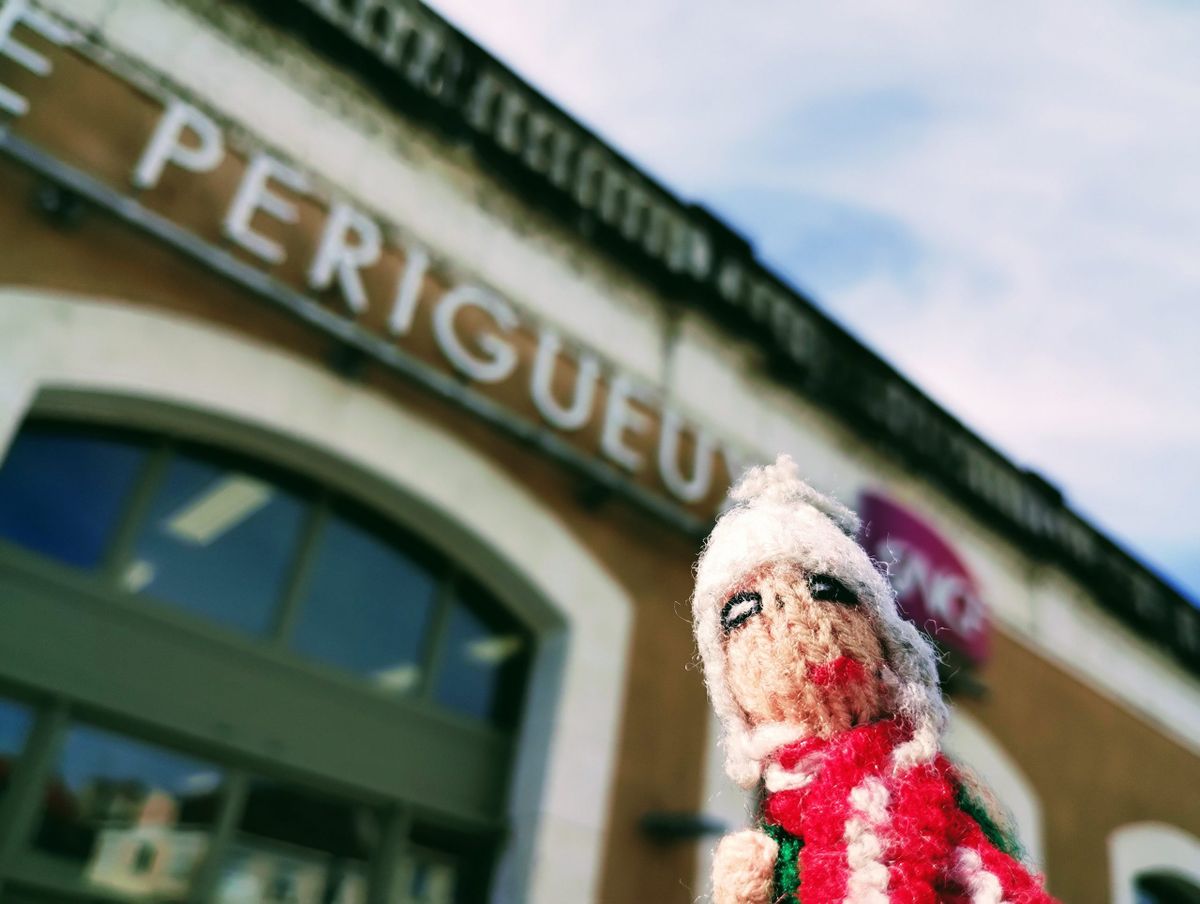 A pensive finger puppet in front of the railway station in Périgueux