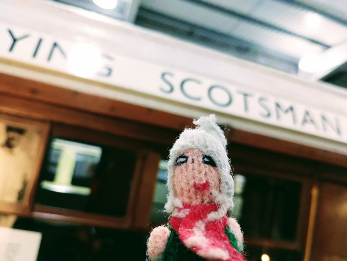 Finger puppet in front of a carriage from The Flying Scotsman.