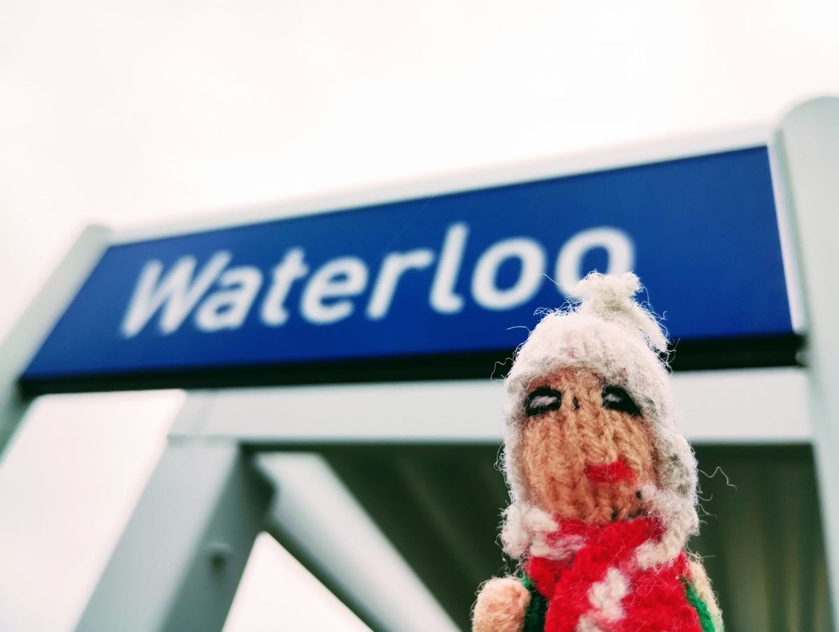 Finger puppet channels its inner Agnetha in front of the station sign at Waterloo, Belgium.
