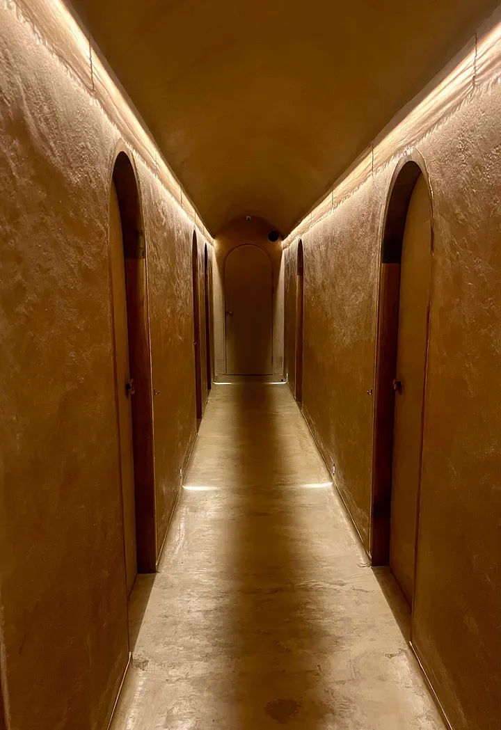 Softly lit arched corridor of treatment rooms at Therapy Day Spa in Pererenan