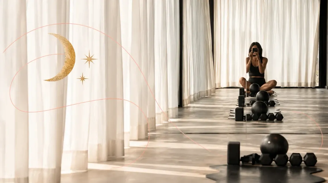 Stevie taking a mirror selfie on a Pilates mat in a sunlit studio with sheer white curtains, framed by an illustrated gold crescent moon and stars