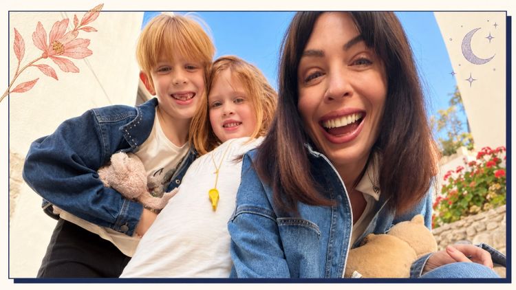 A laughing mum taking a selfie with her two young kids on a sunny Greek island street