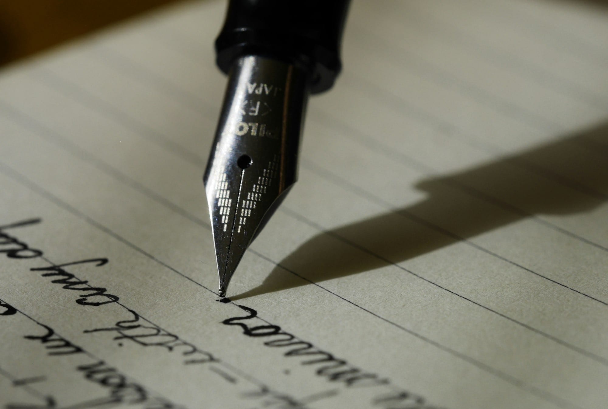 fountain pen on black lined paper