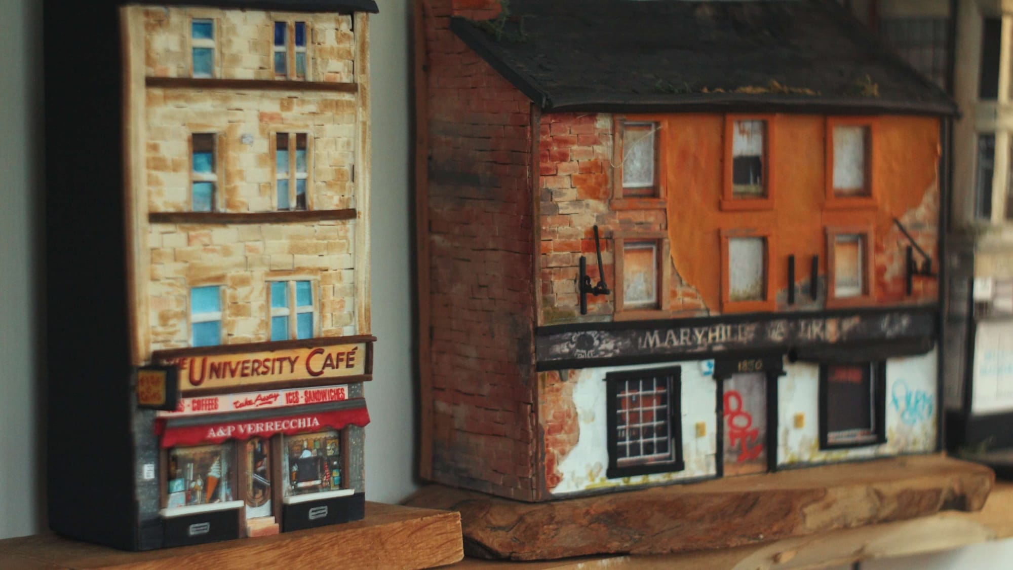 Tiny replicas of Glasgow buildings with shop signs and graffiti