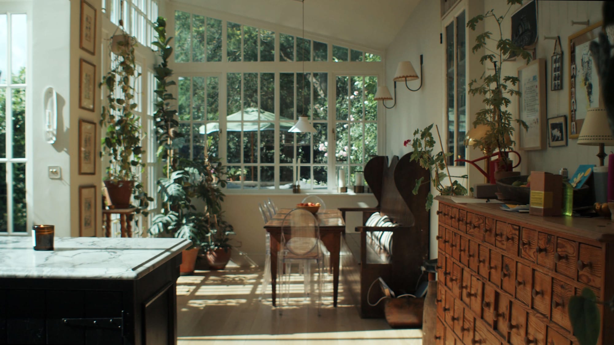 ChatGPT said:  A bright conservatory-style dining space filled with plants, wooden furniture and sunlight