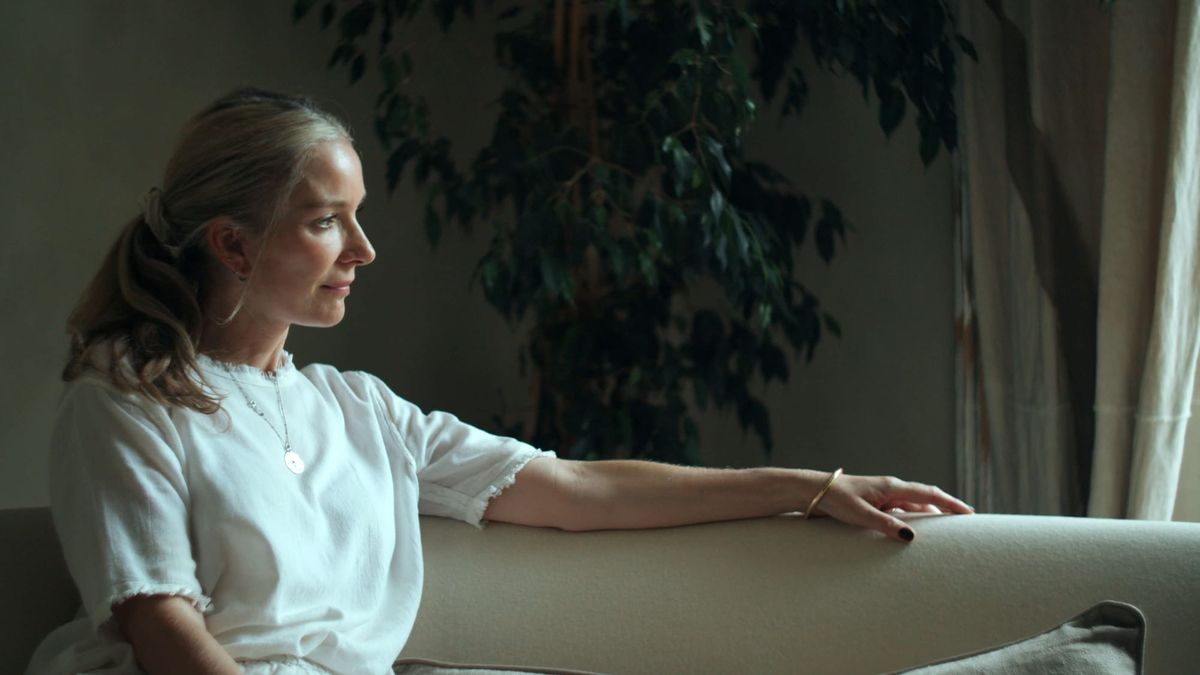 Louisa Grey sitting on a neutral sofa in her peaceful North London home
