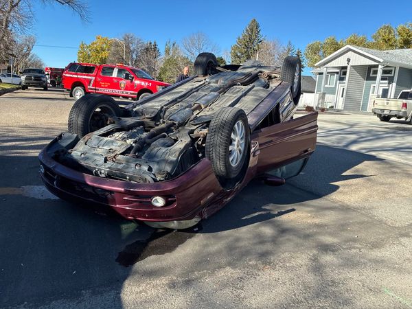 A car on its roof at the scene of a collision in Taber.