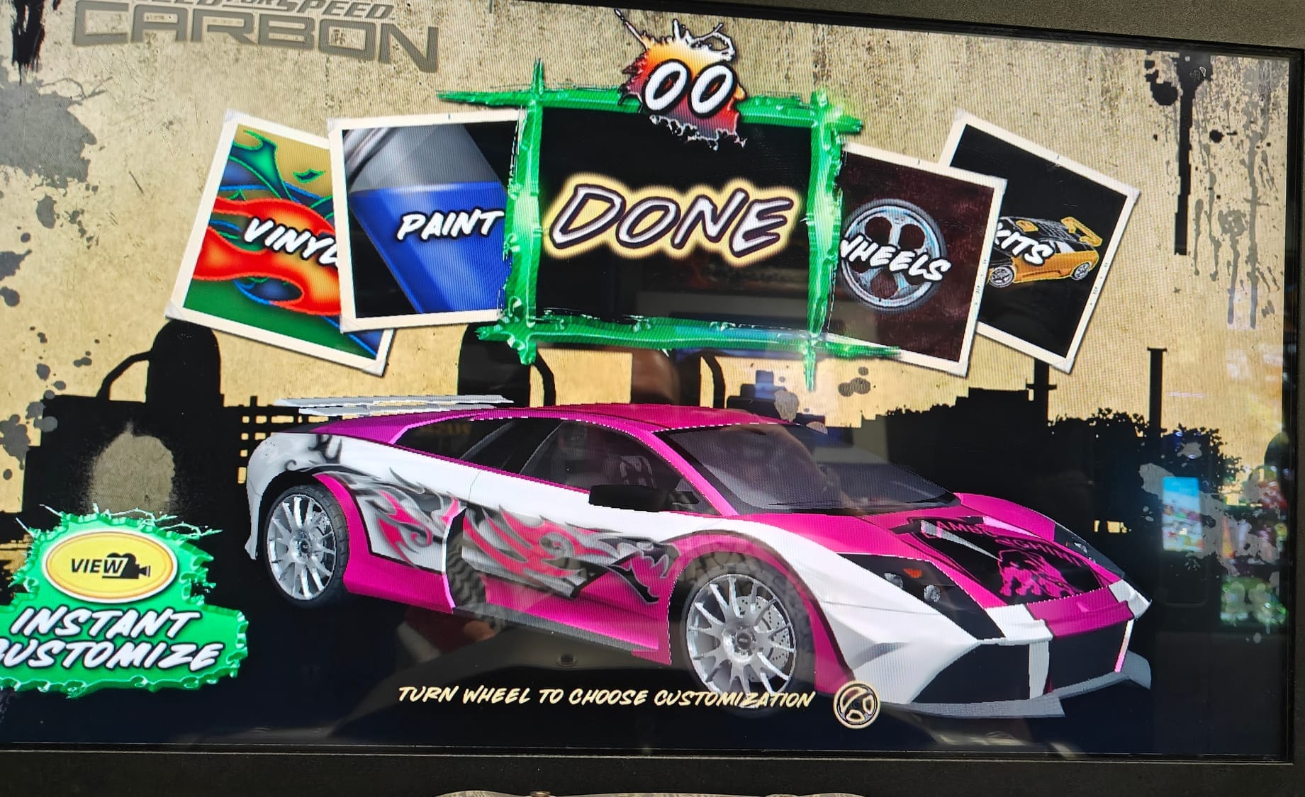 The customization menu for Need For Speed Carbon arcade. There are four customization options, two on each side of the done button in the middle. The Lamborghini Murciealago that's been chosen is white, with a pink top and side skirts and fenders.
