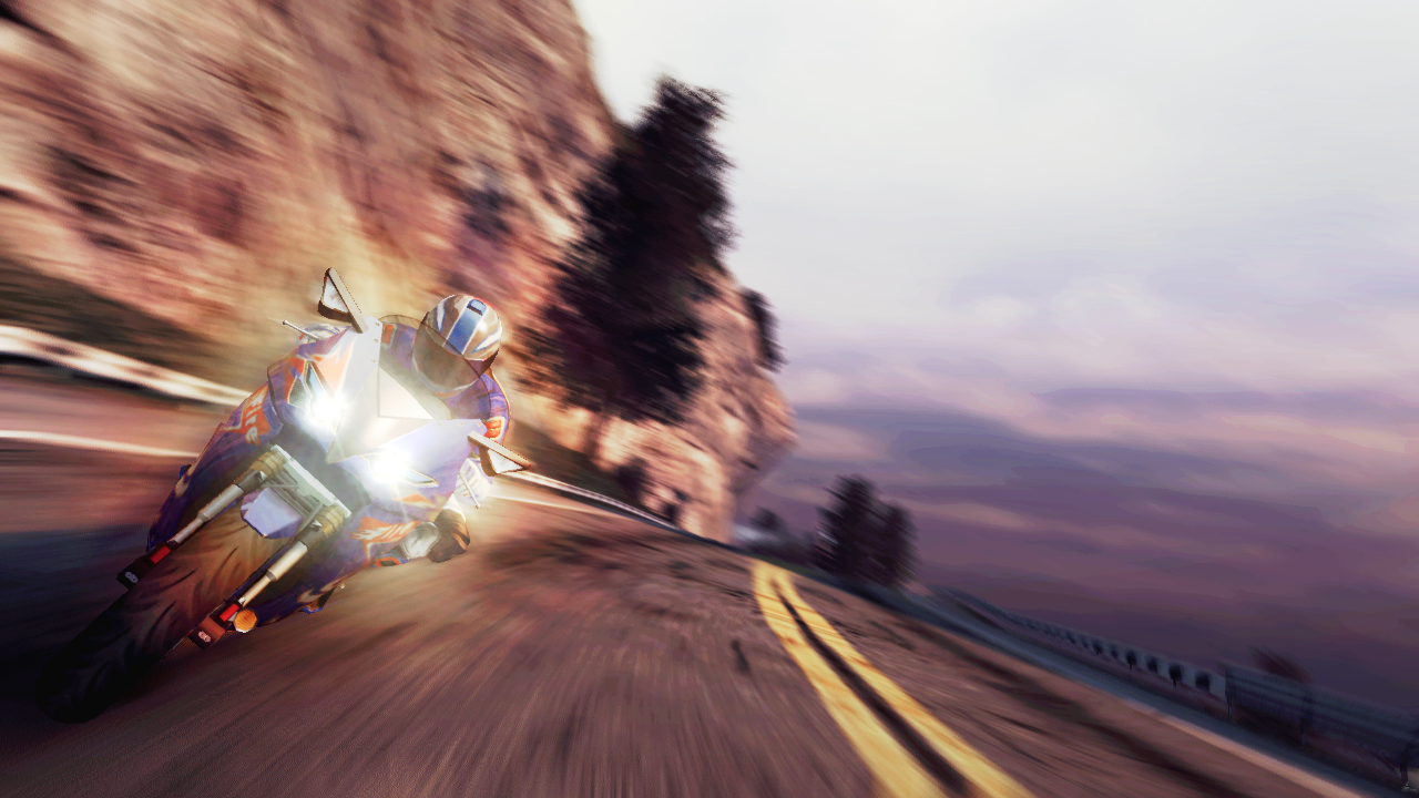 A screenshot from Burnout Paradise showing a blue and red super bike driving at speed on a two lane mountain road.