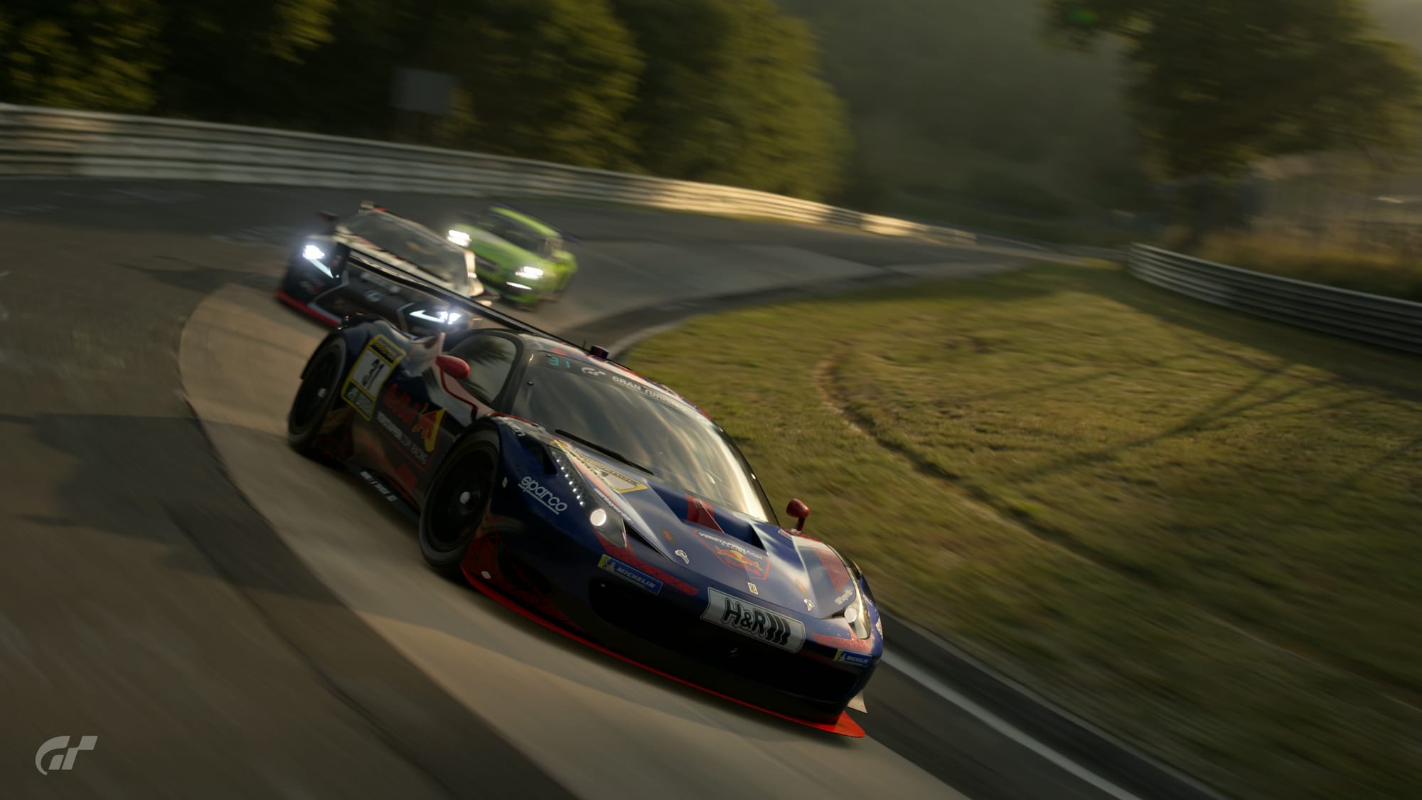 A dark blue with red Ferrari 458 Italia GT3 leads a black Lexus LC500 and a bright green Porsche Cayman through the Karussell at the Nurburgring. This is a screenshot from Gran Turismo 7.
