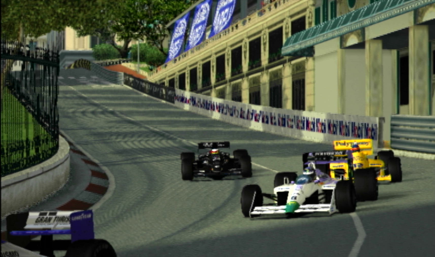 A quartet of open wheel race cars entering the Mirabeau hairpin at the Monaco Grand Prix street circuit.