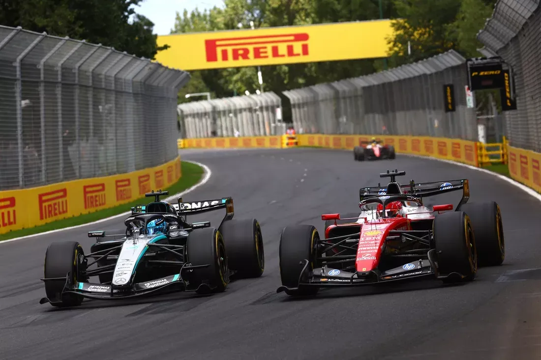 The silver and black Mercedes F1 car driven by George Russell going for an overtake on the red Ferrari of Charles Leclerc during the 2026 Australian Grand Prix. Looming in the background is Lewis Hamilton catching the battling pair.