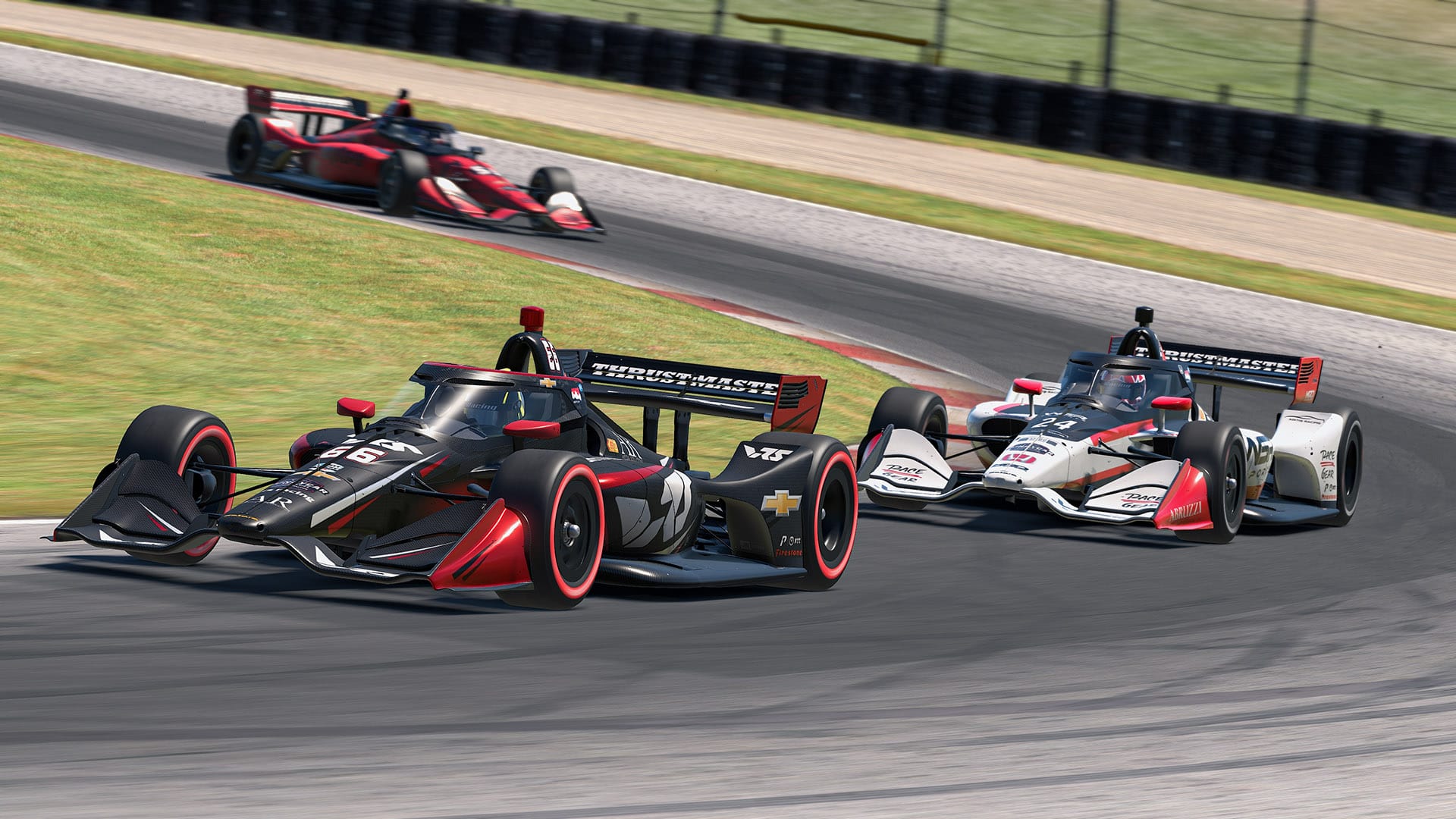 Three Dallara iR18 Indycars battling for position at the Mid-Ohio Sports Car Course. They are being led by a black, with red and white VRS branded machine.